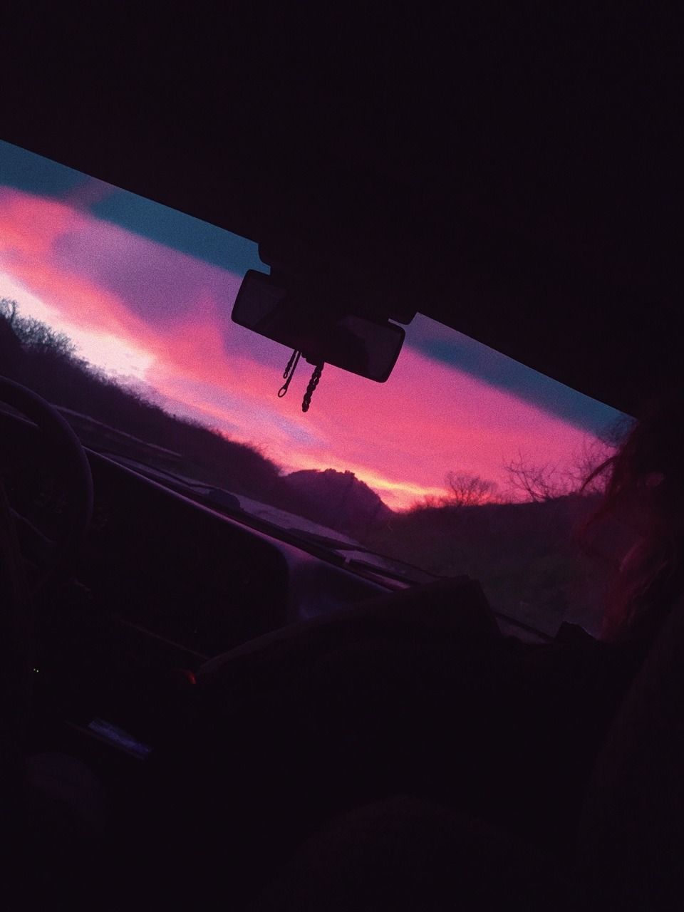 A car dashboard with a beautiful sunset in the background. - Sunshine