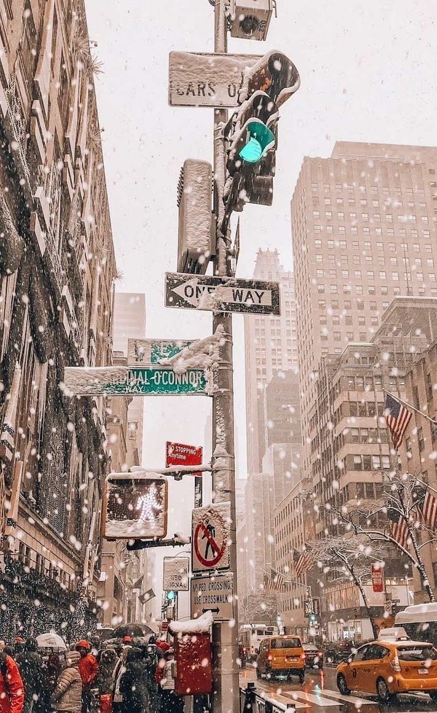 A street sign with snow falling down - New York