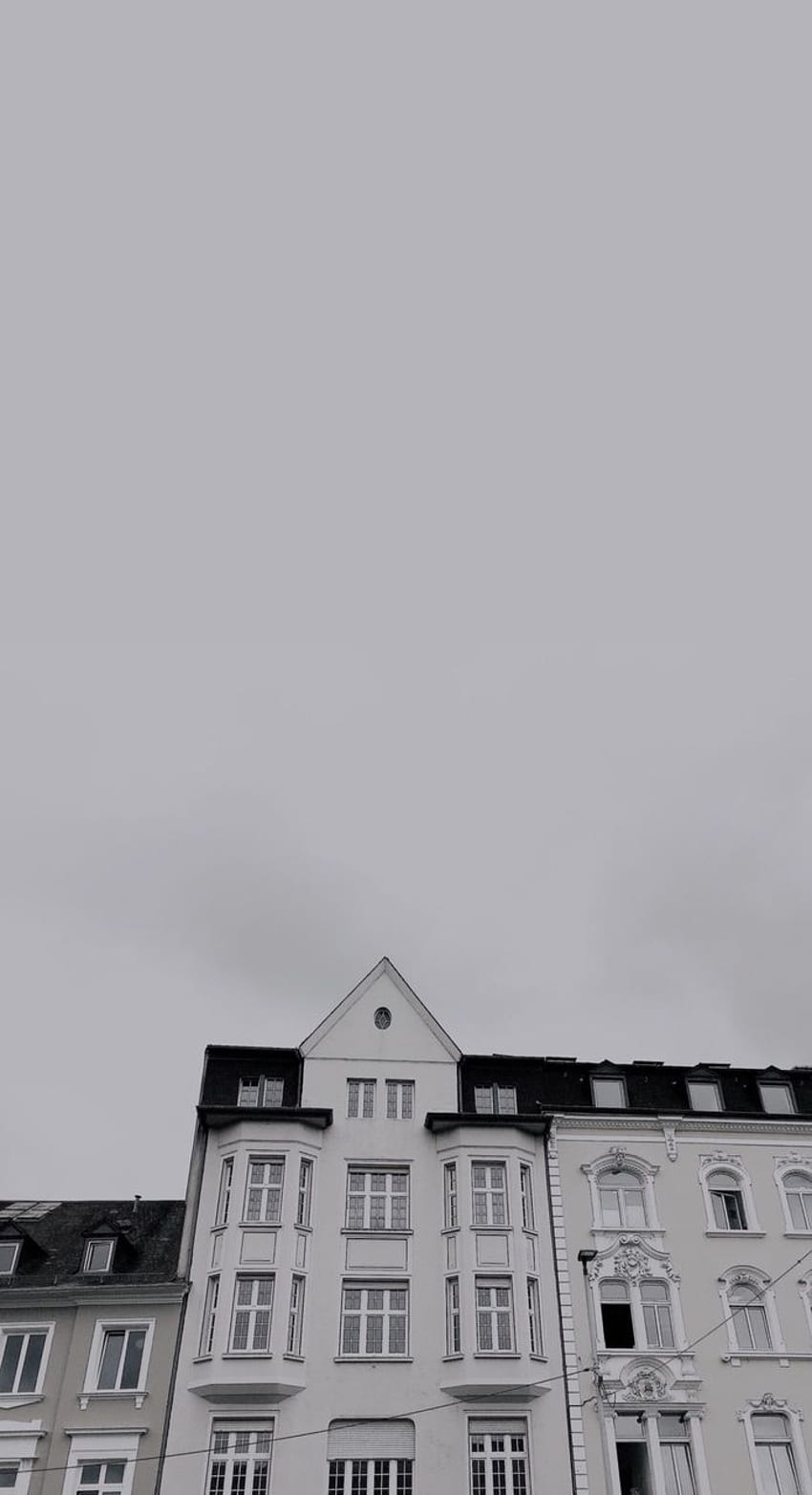 A white building with a clock on the top. - Gray