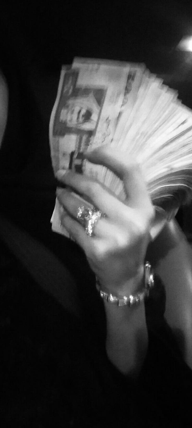 A woman holding a stack of money. - Money