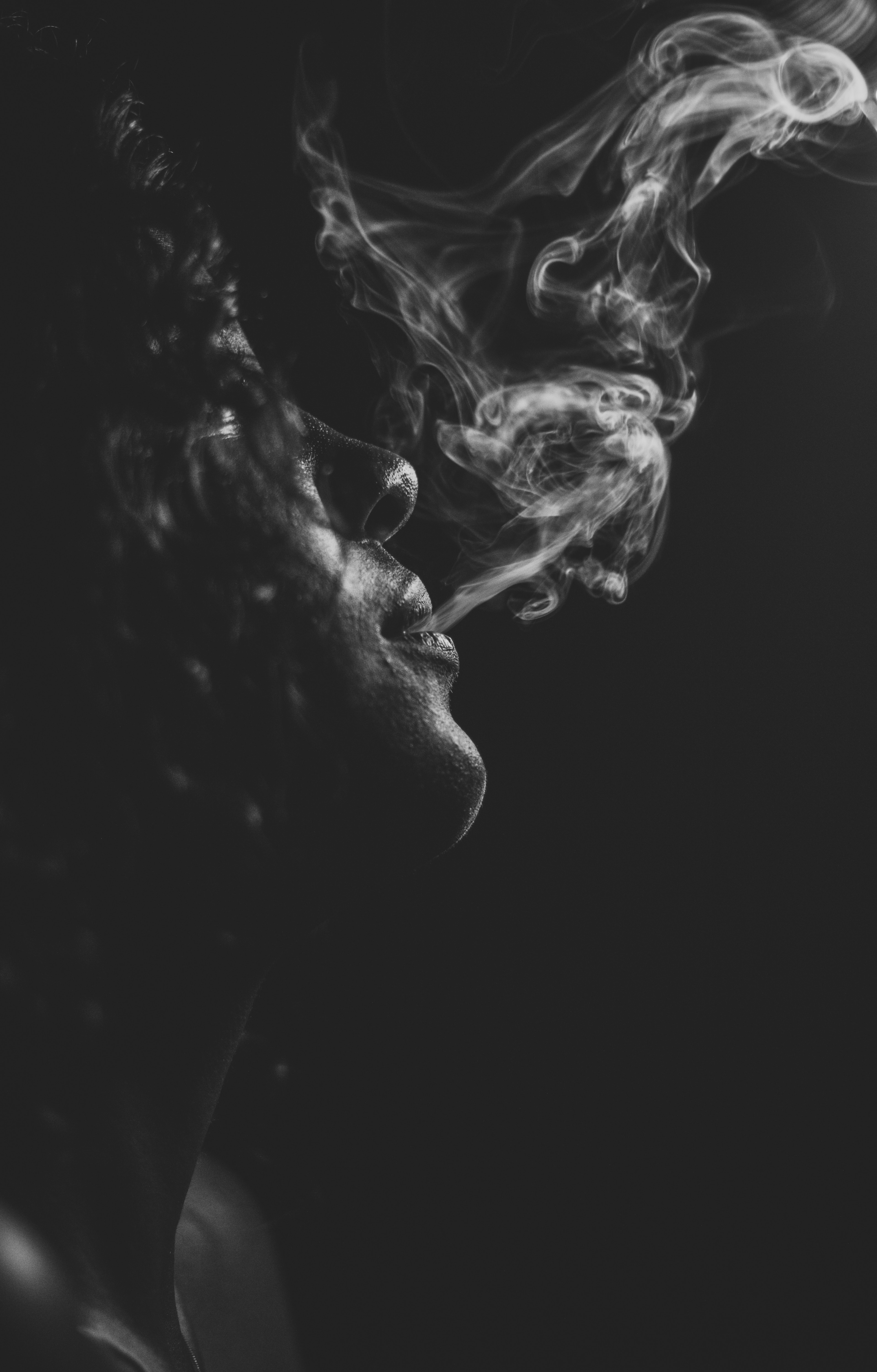 A woman smoking in the dark - Smoke