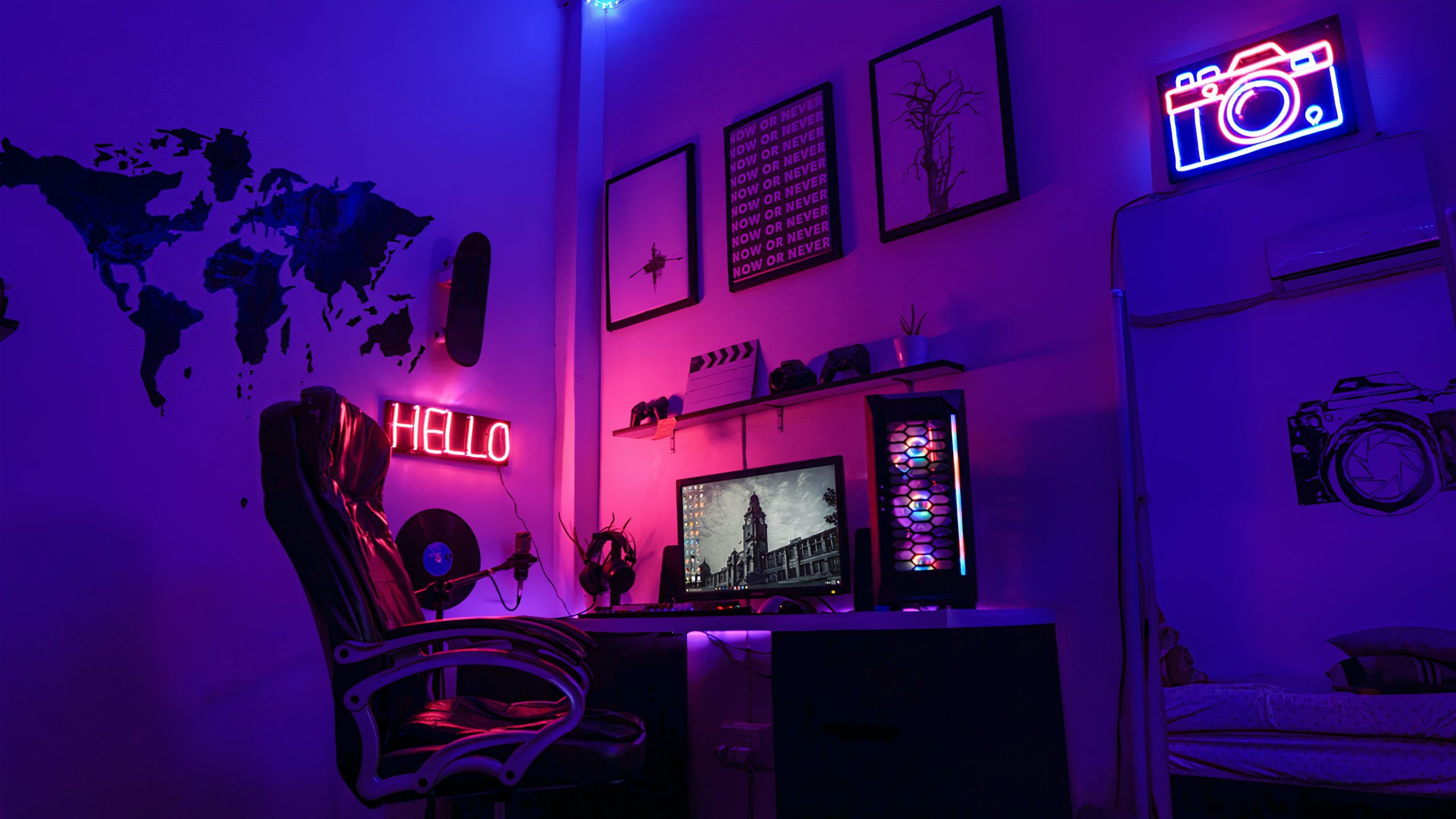 A gaming room with purple and blue neon lights, a gaming chair, and a computer. - Gaming