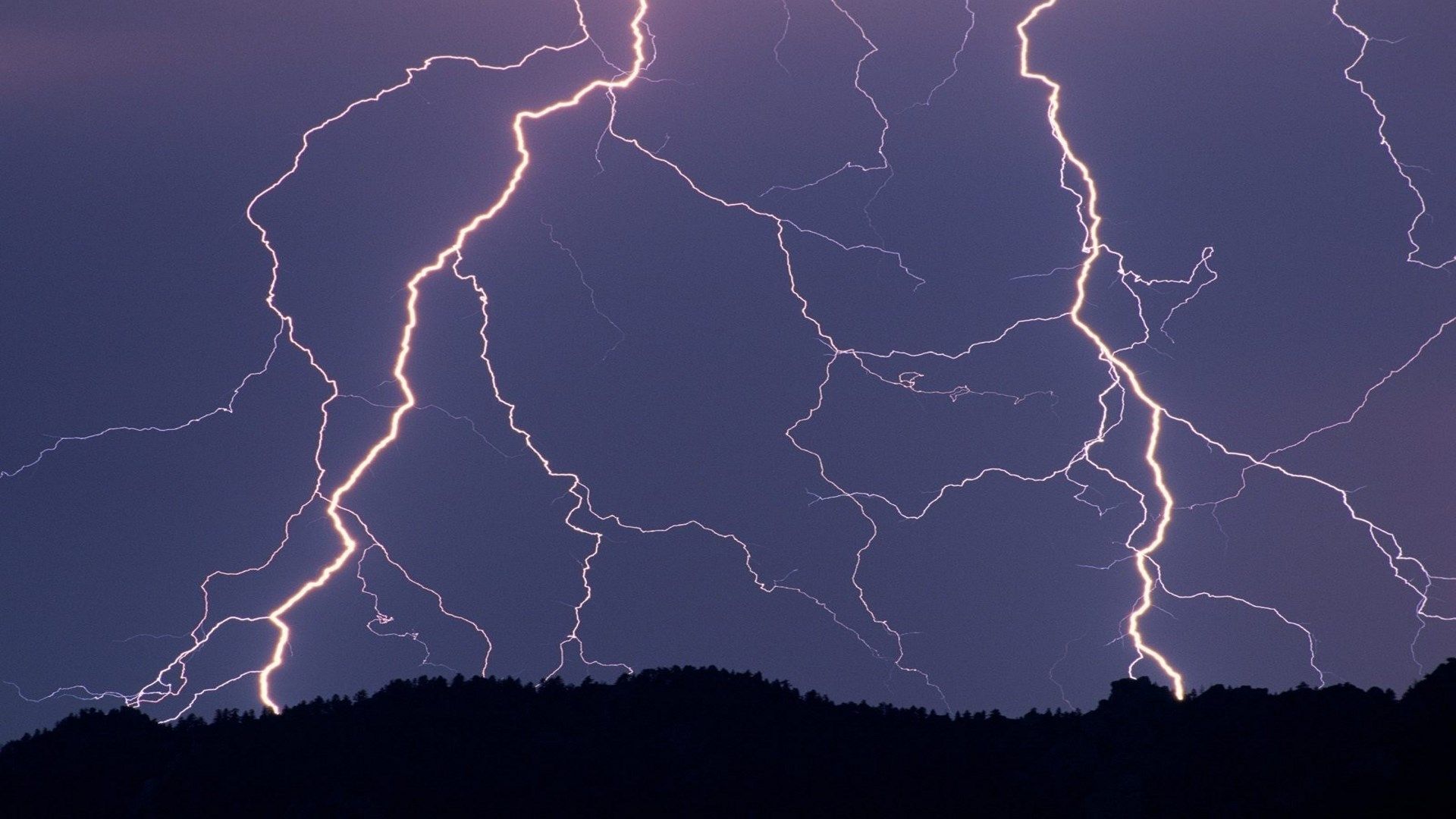 A photo of lightning bolts striking the ground in the distance - Lightning