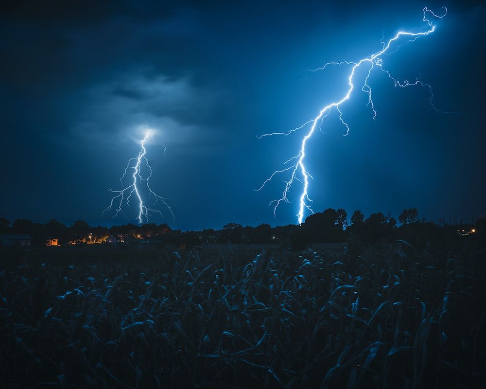 A lightning bolt strikes the ground in front of some corn - Lightning