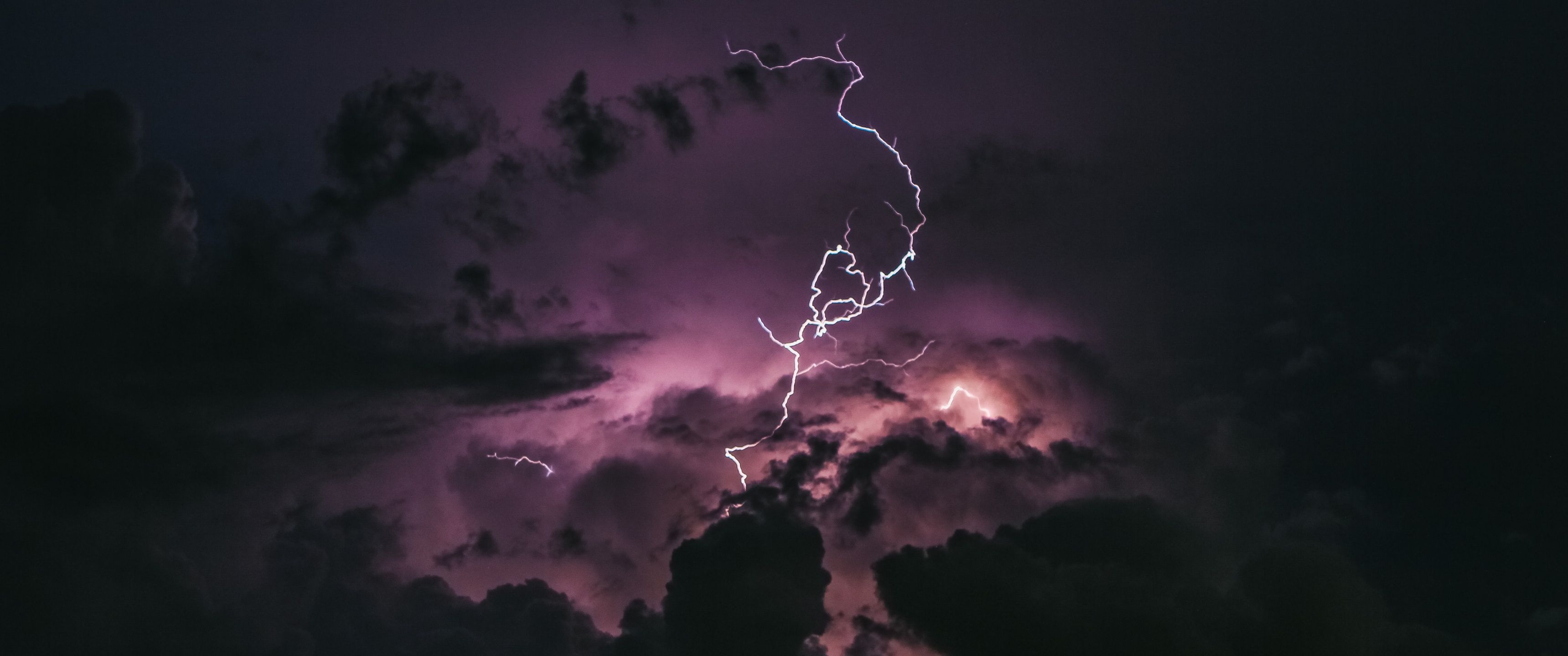 A purple lightning bolt is seen in the sky - Lightning