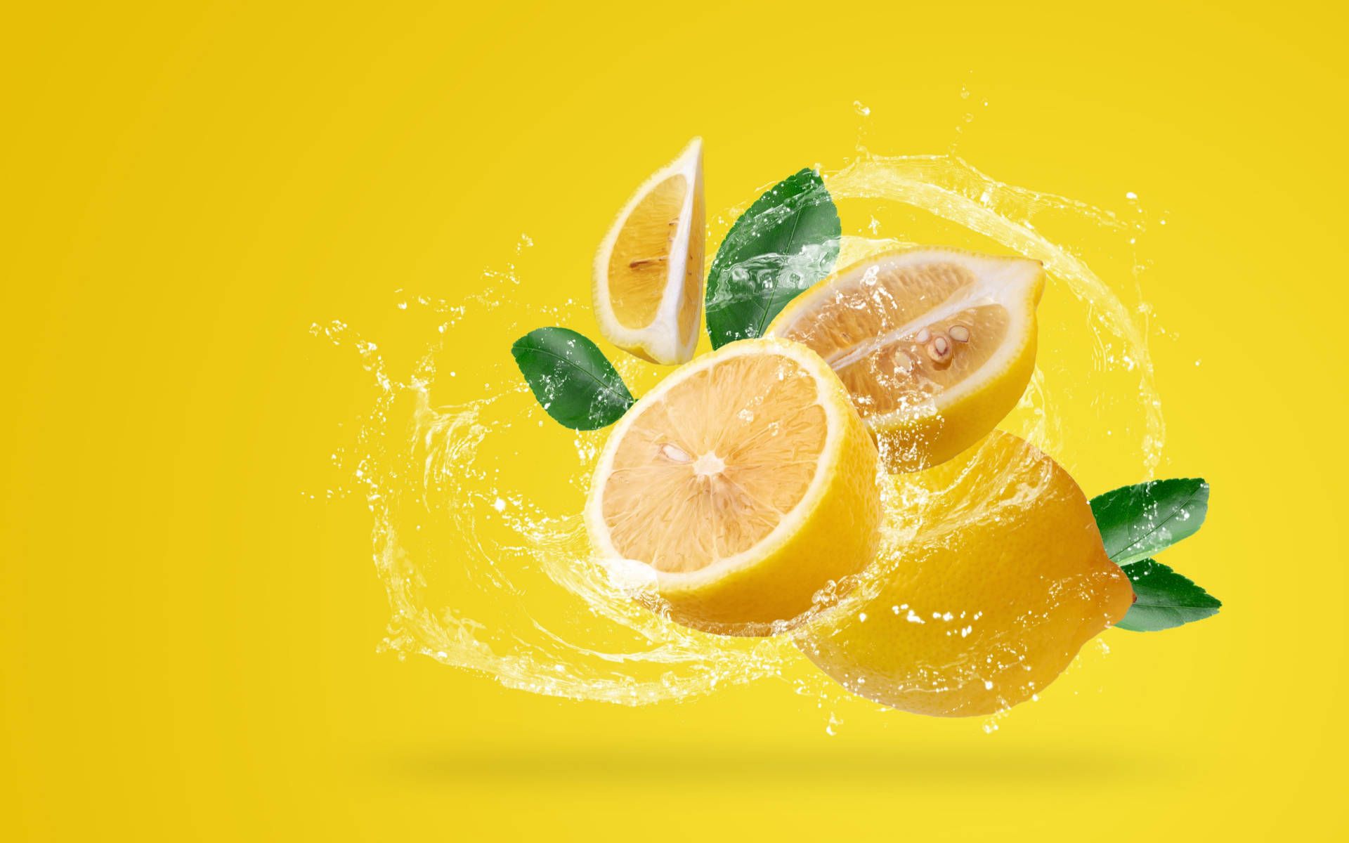 Lemon juice splashing on yellow background - Lemon