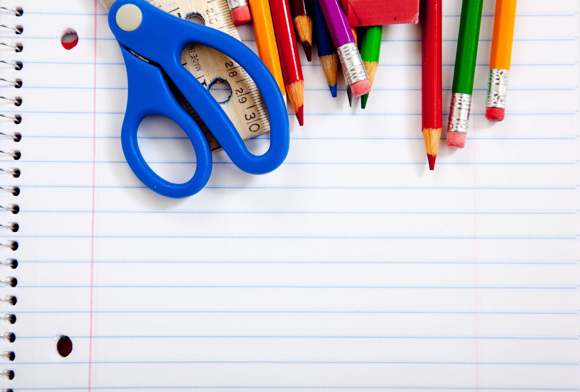 A notebook with pencils, scissors and other school supplies - School