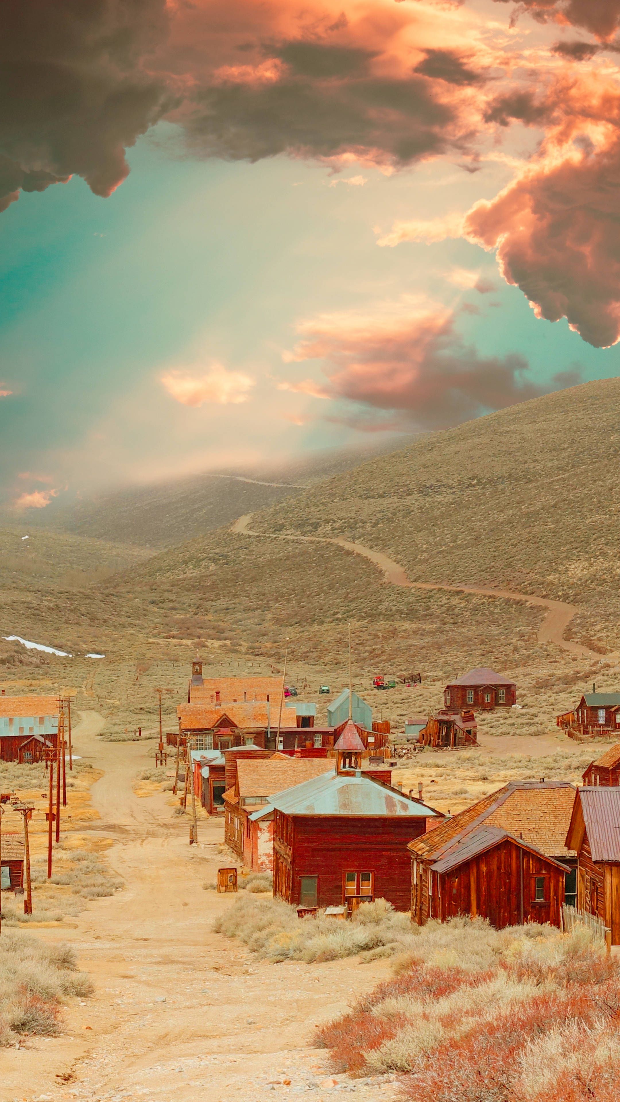 A town in the middle of a desert with a cloudy sky above. - Western