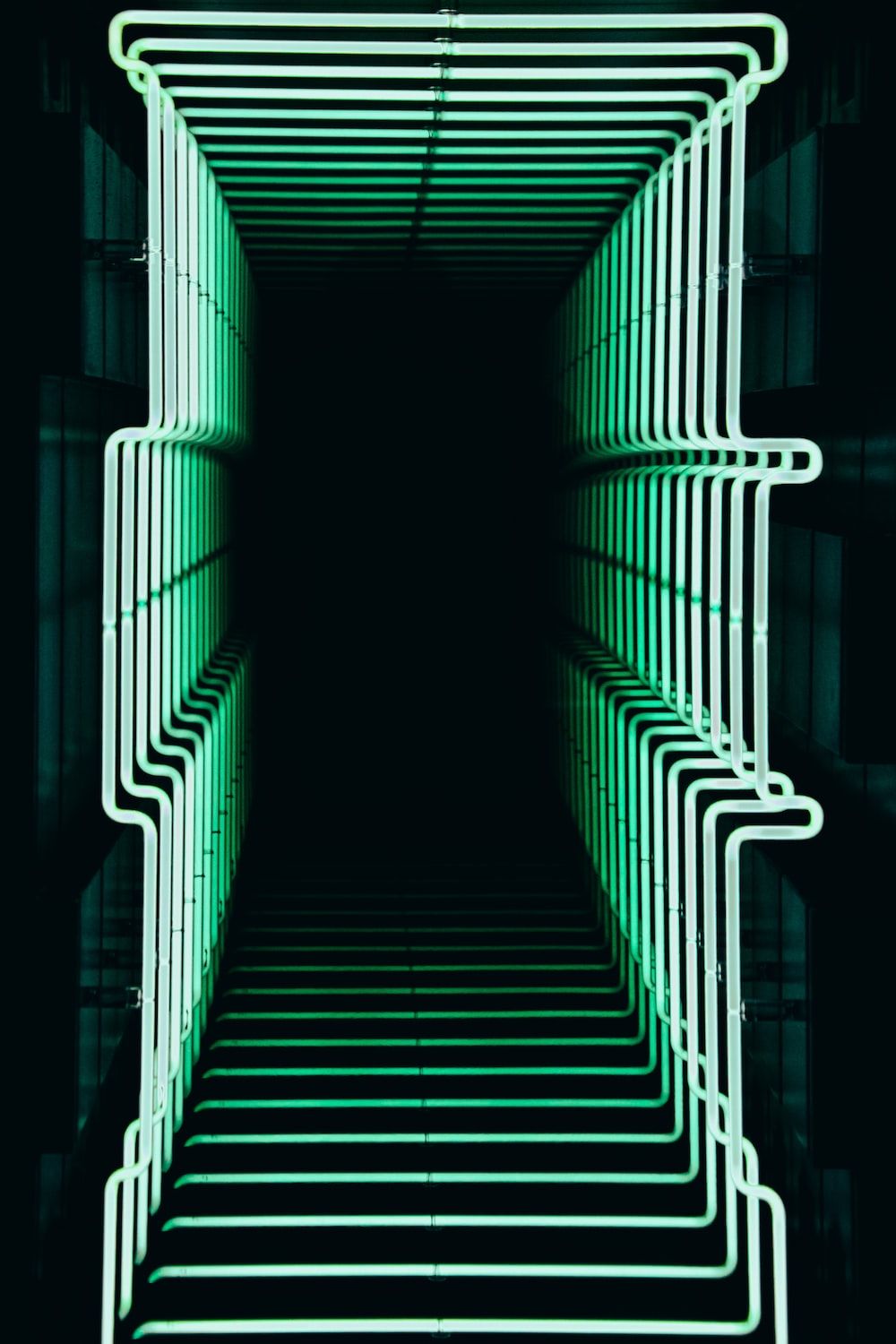 A neon green light sculpture in a dark room. - 3D