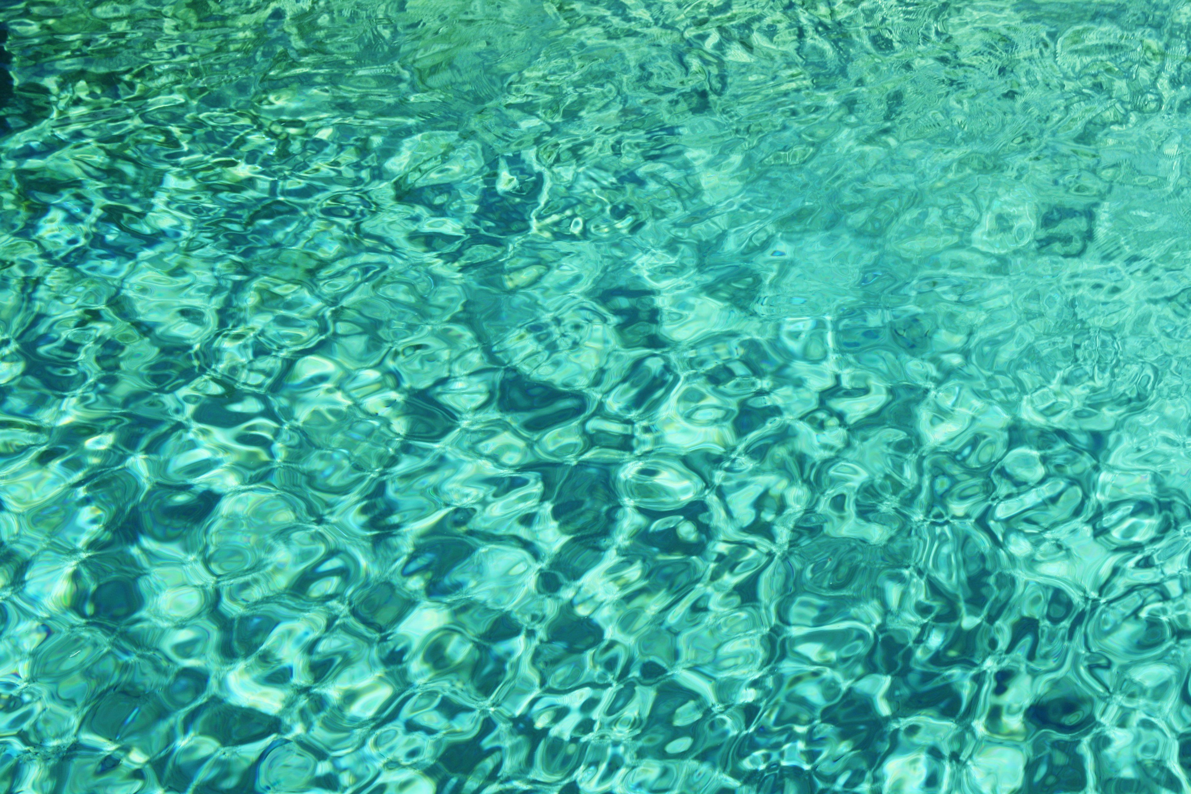 A pool of water with a blue and green reflection. - Aqua