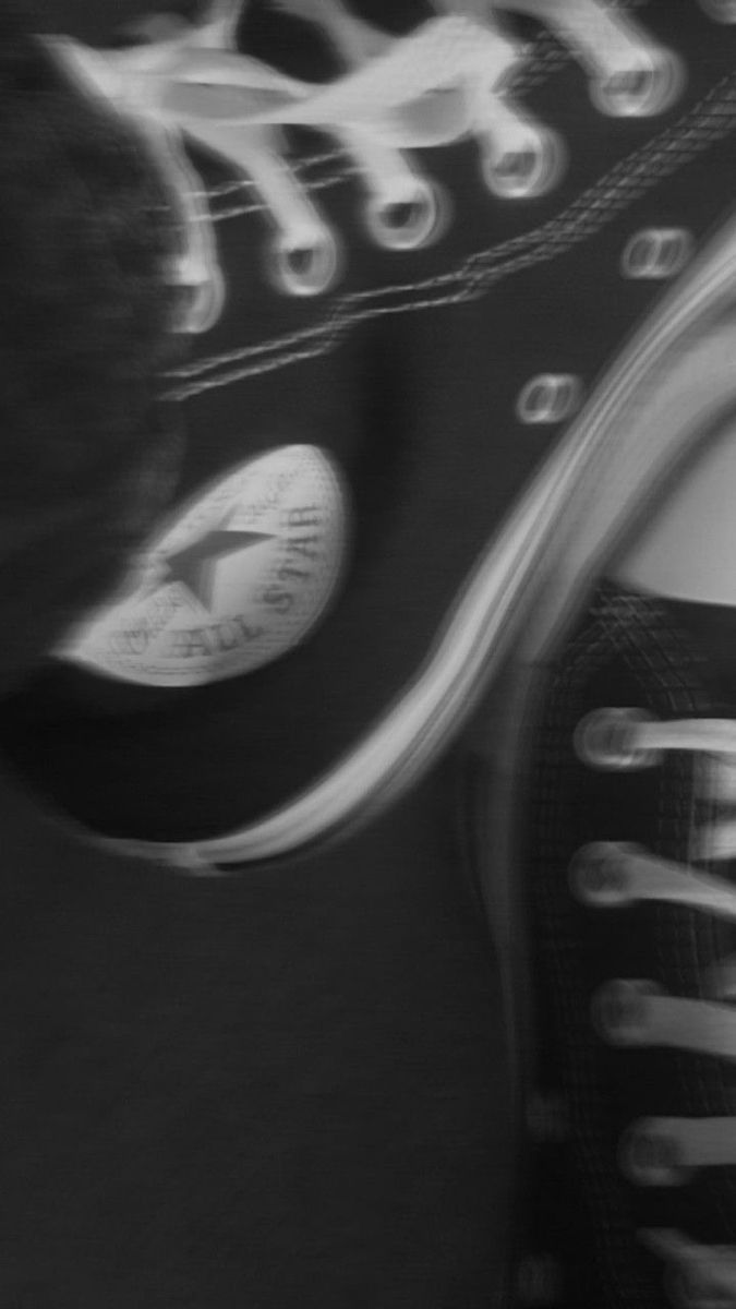 A close up of a black Converse shoe with the logo in the forefront. - Converse