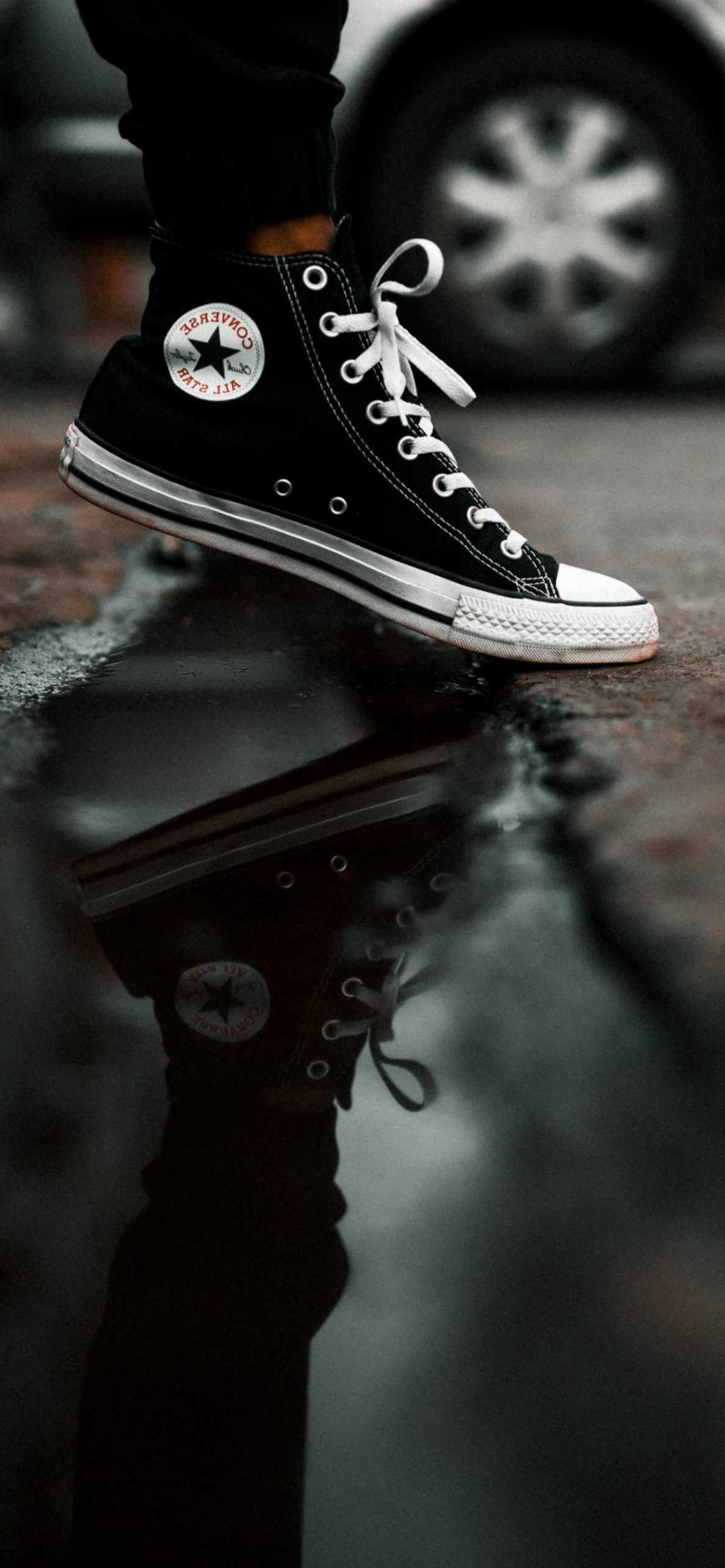 Black Converse shoes on a puddle of water - Converse