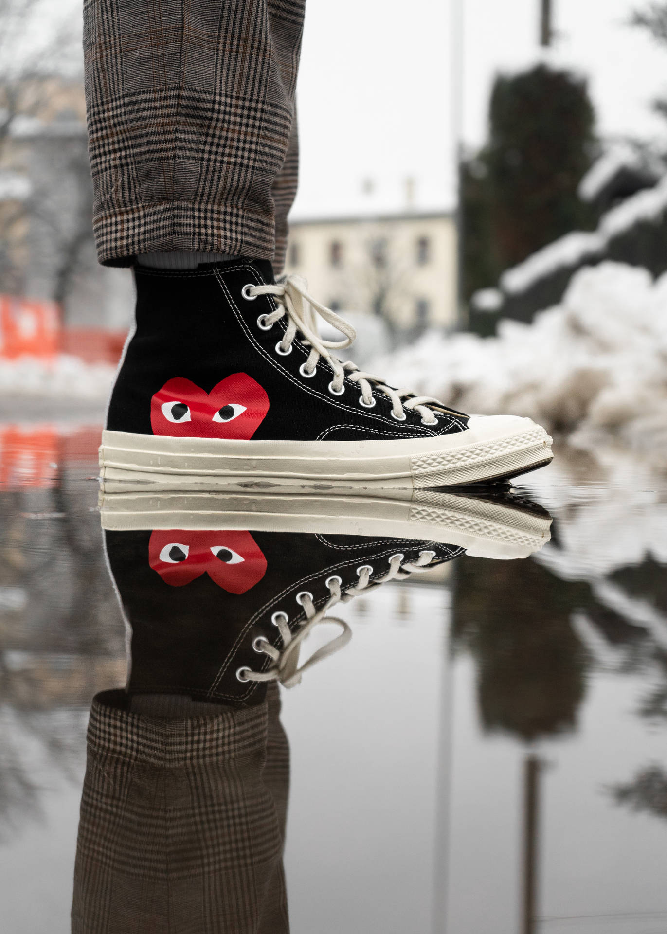 A person standing in water with their shoes on - Converse