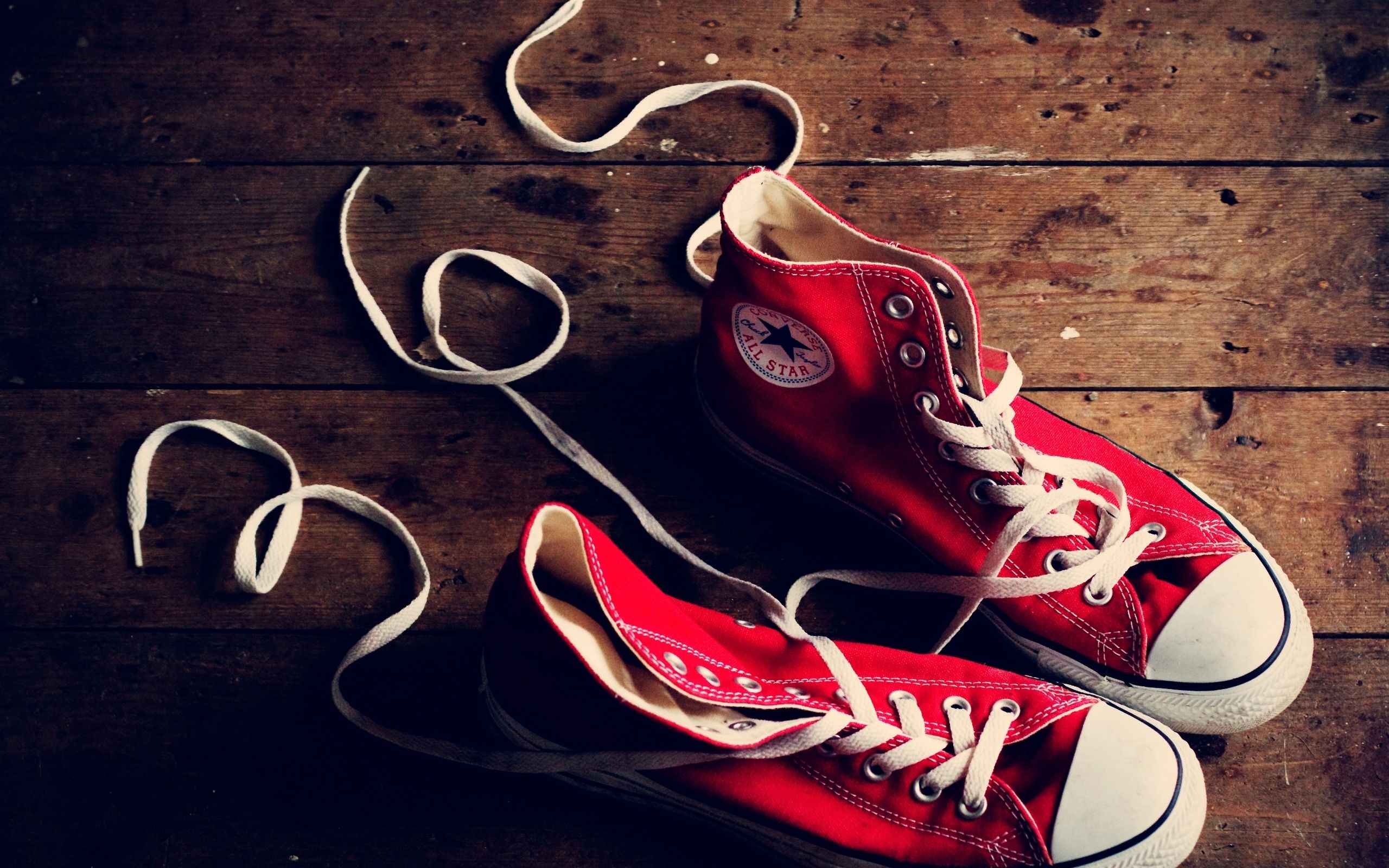 A pair of red sneakers on the floor - Converse