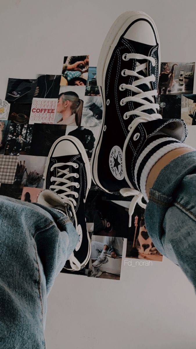 Converse shoes on a bed with a photo wall - Converse