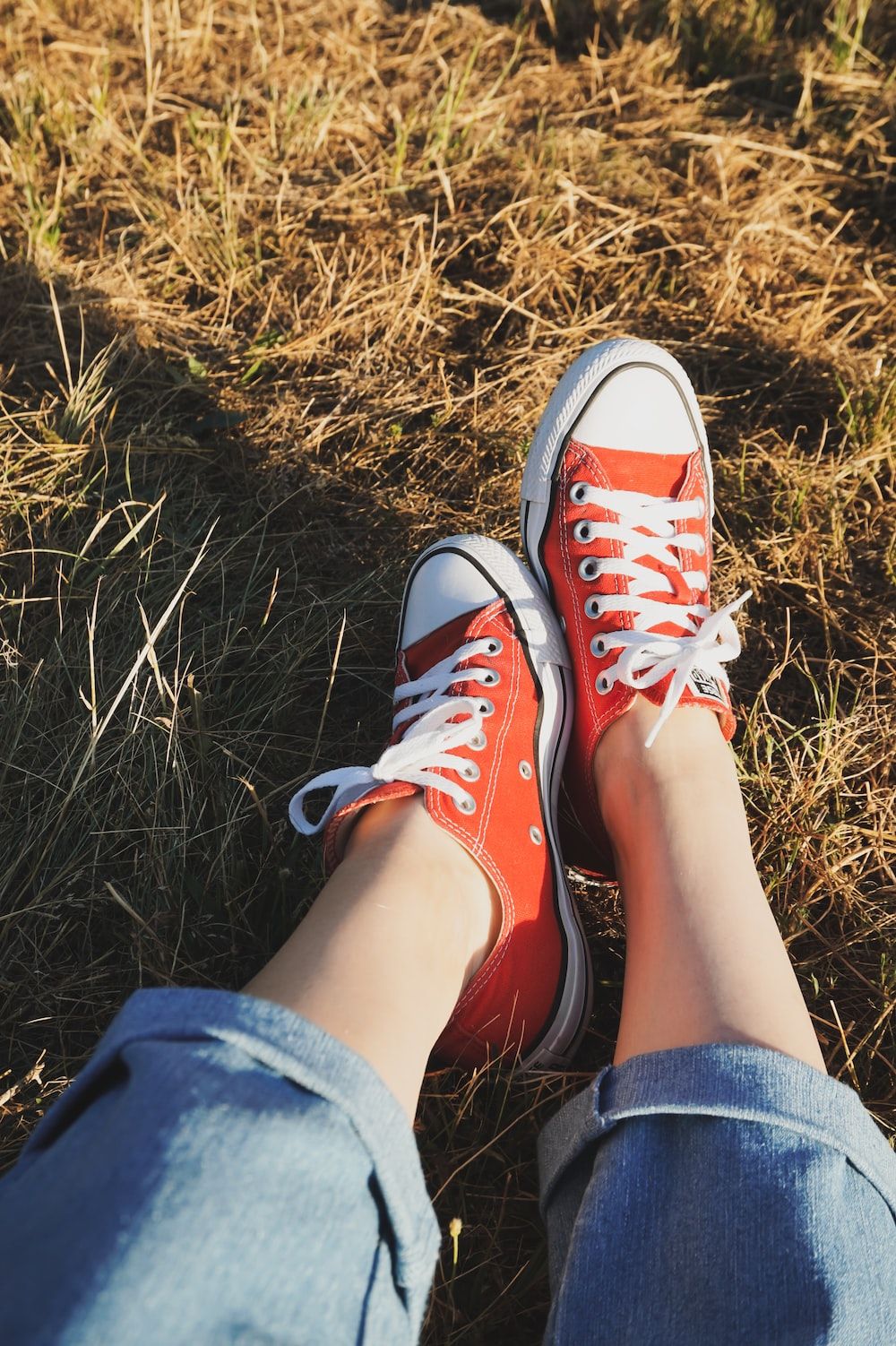 A person wearing red converse sneakers - Converse