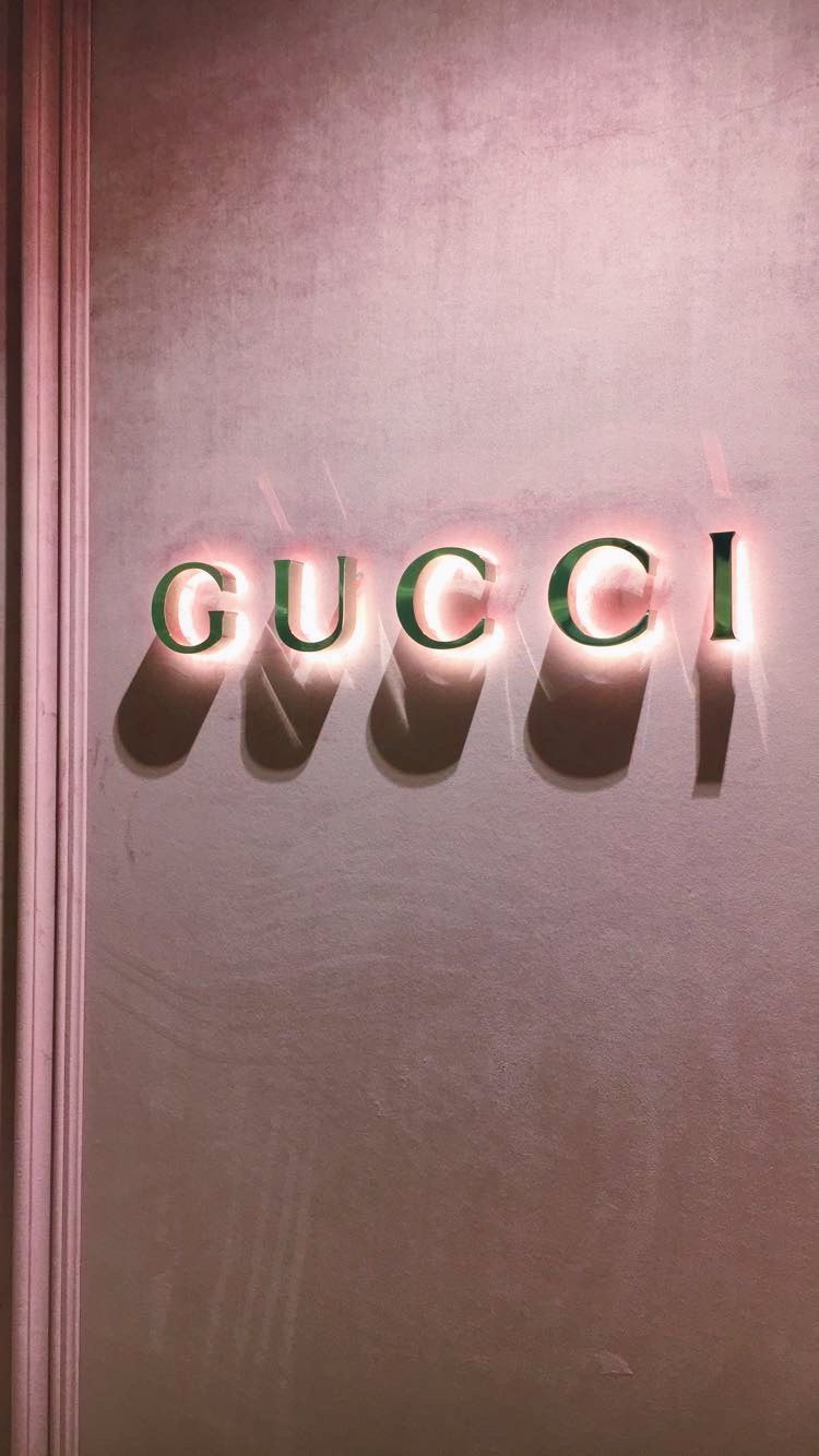 A close up of the gucci logo on an interior wall - Gucci