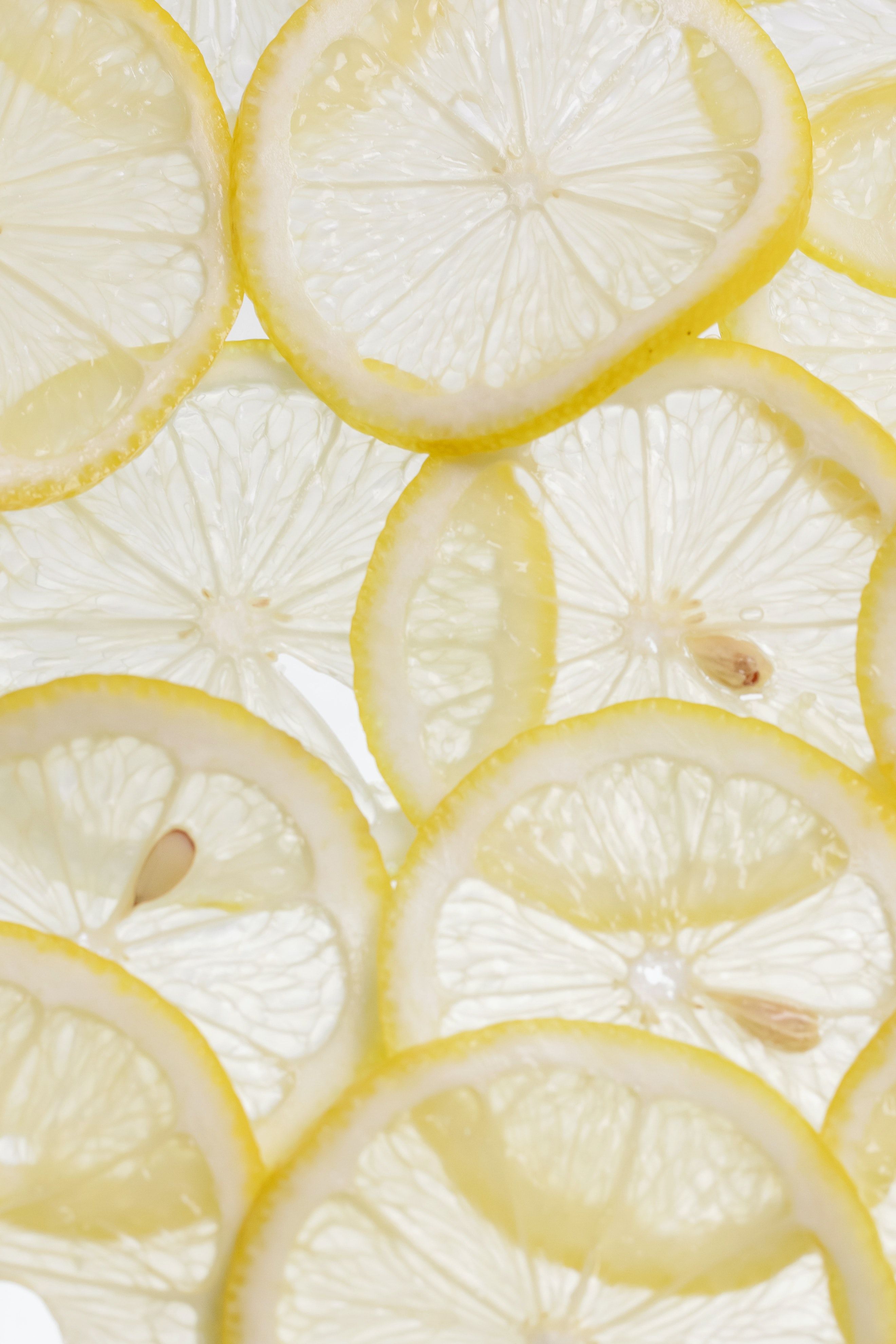A close up of sliced lemons on a white background. - Lemon