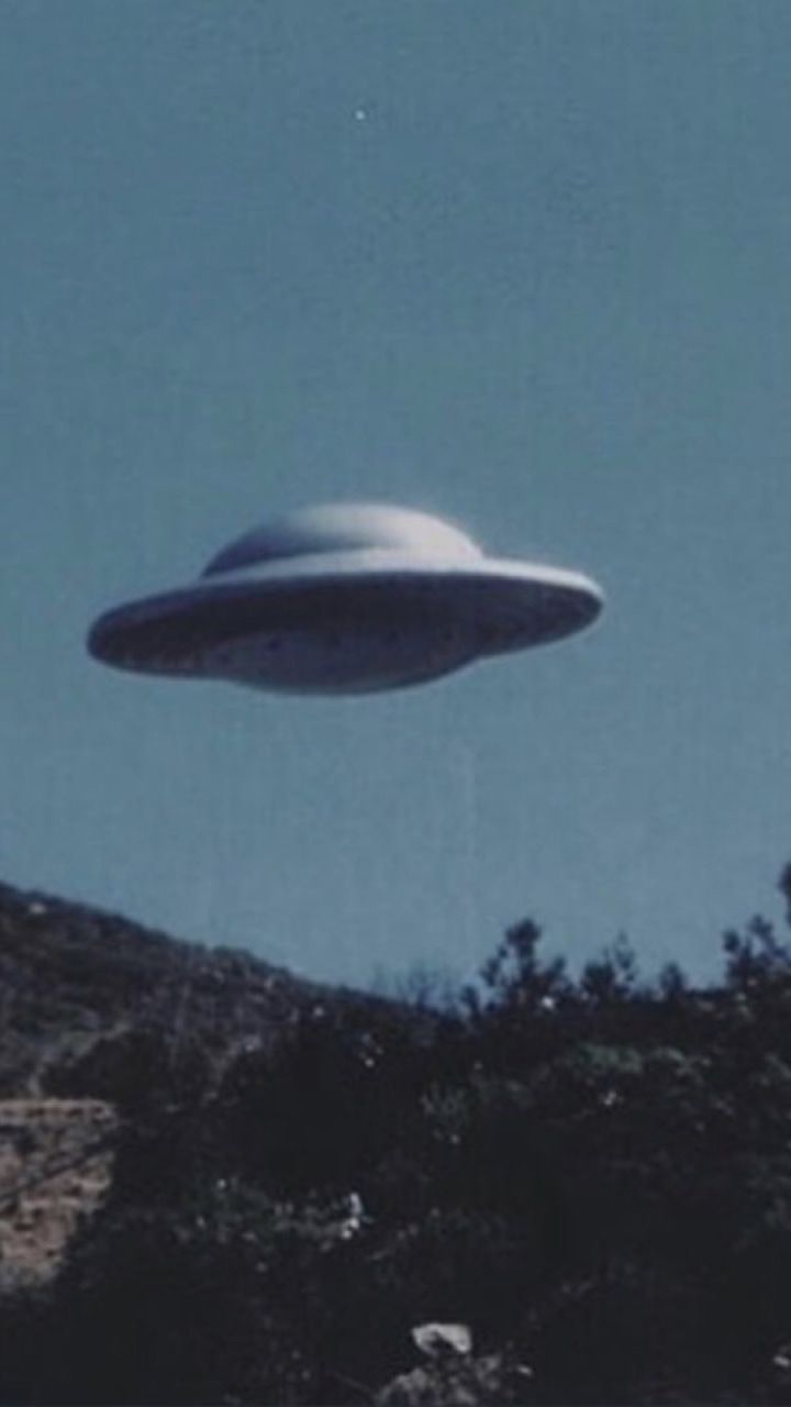 A flying saucer over a mountain. - Alien