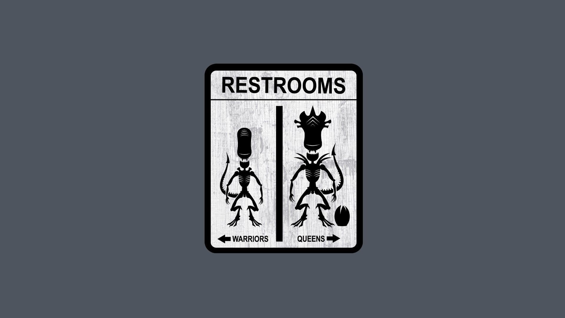 A restroom sign with two alien creatures on it, one says 