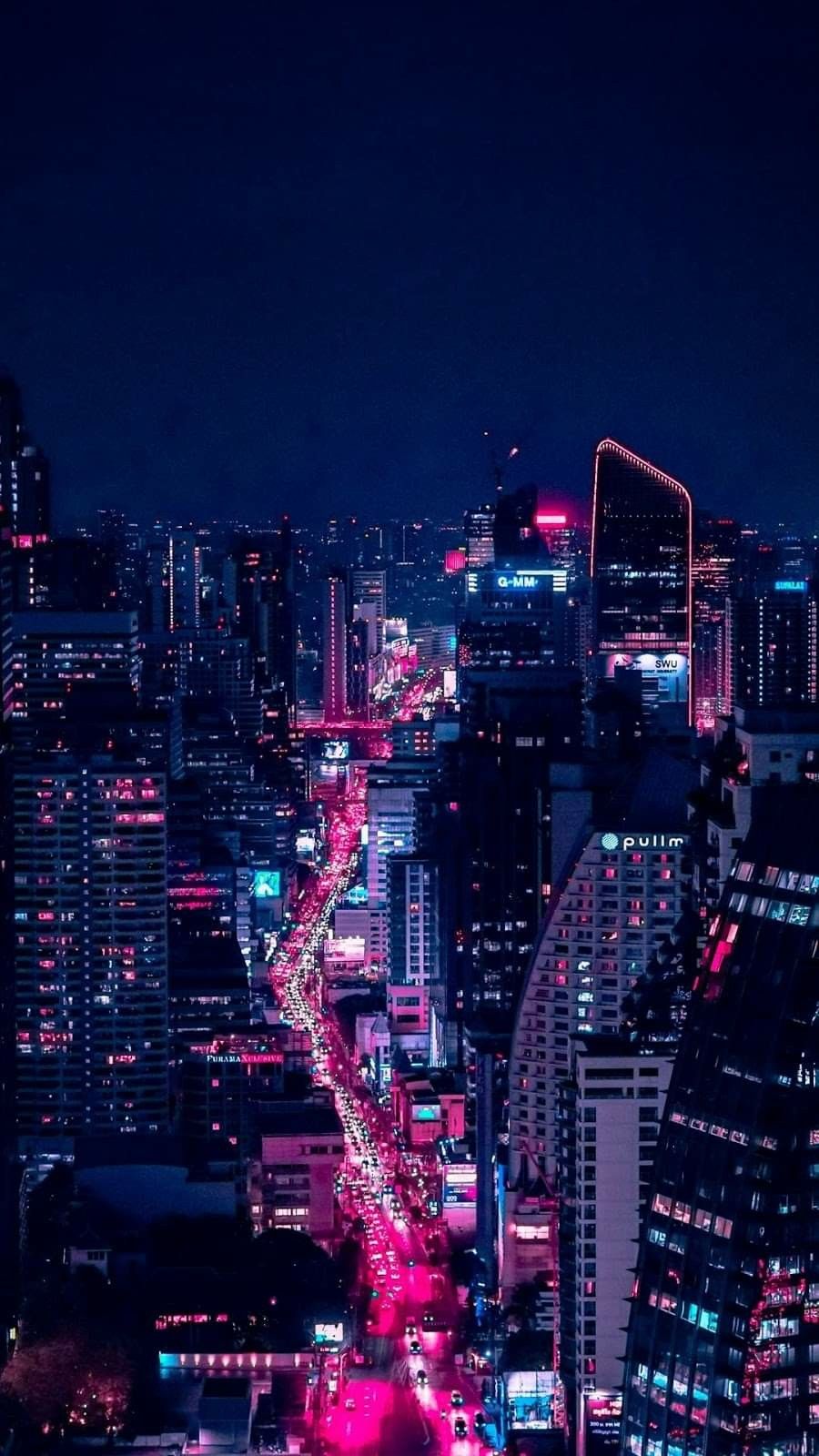A city at night with bright lights and buildings - City