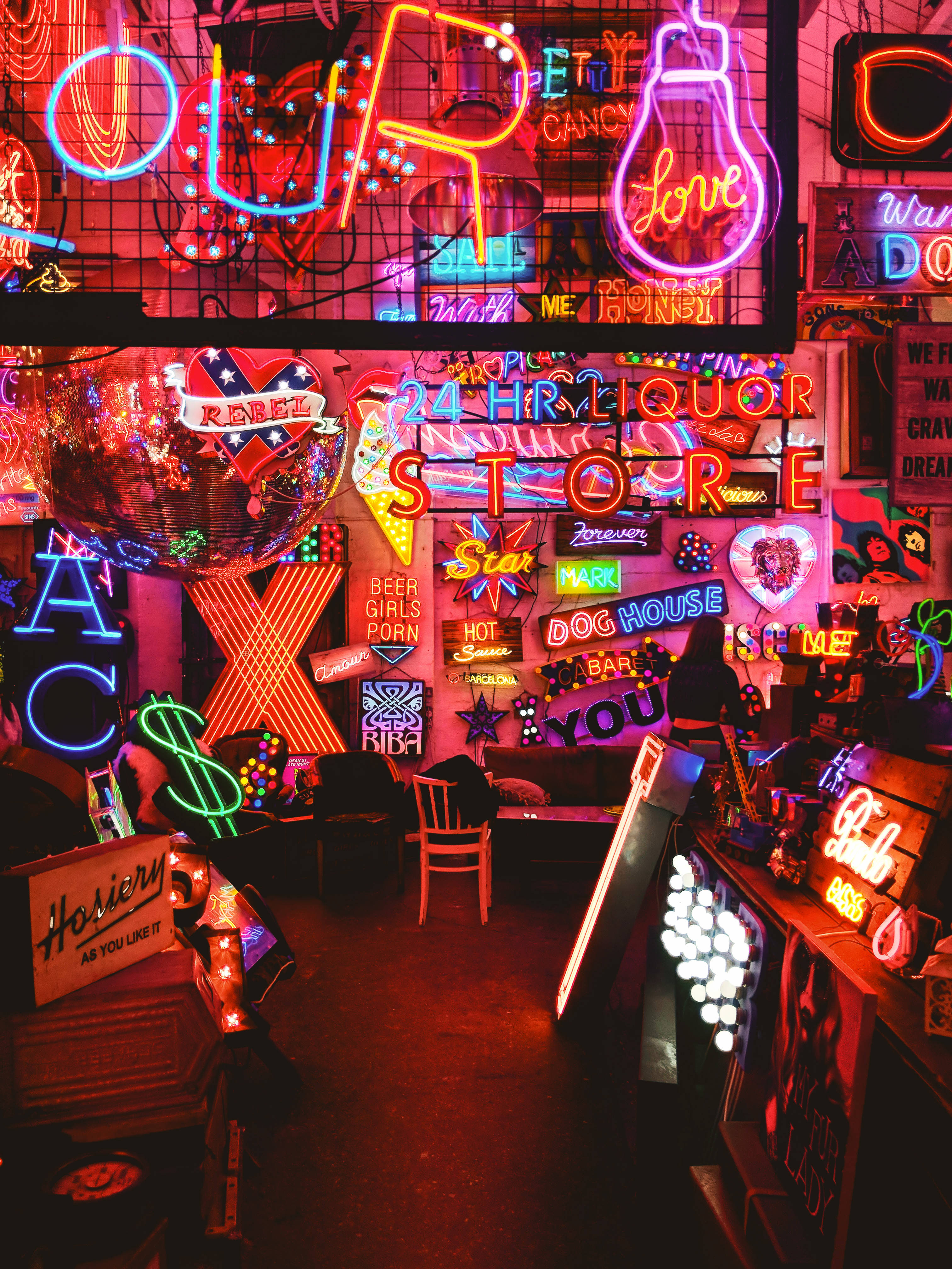 A room filled with a variety of different colored neon signs. - Neon
