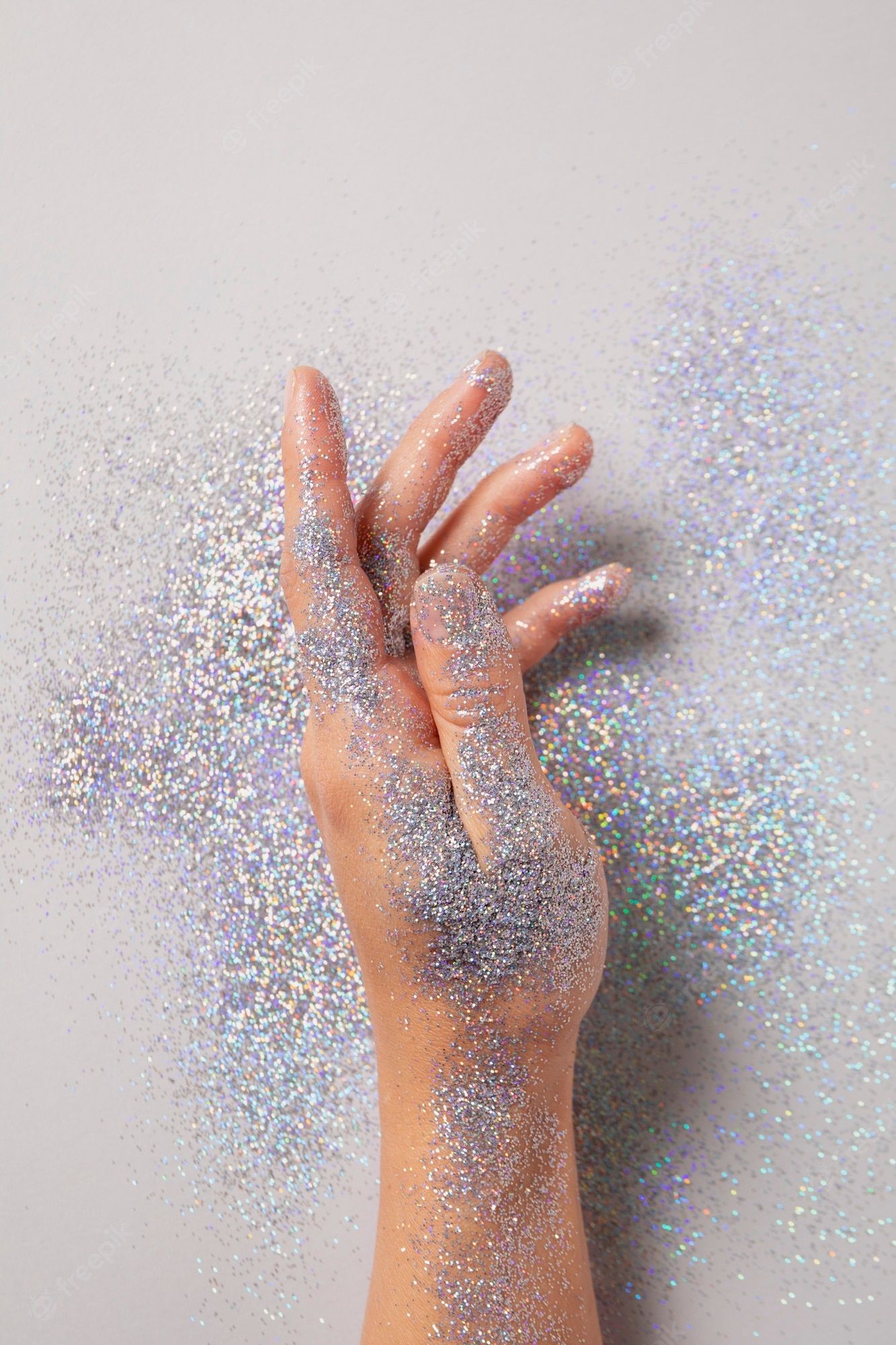 A hand holding glitter over white background - Silver