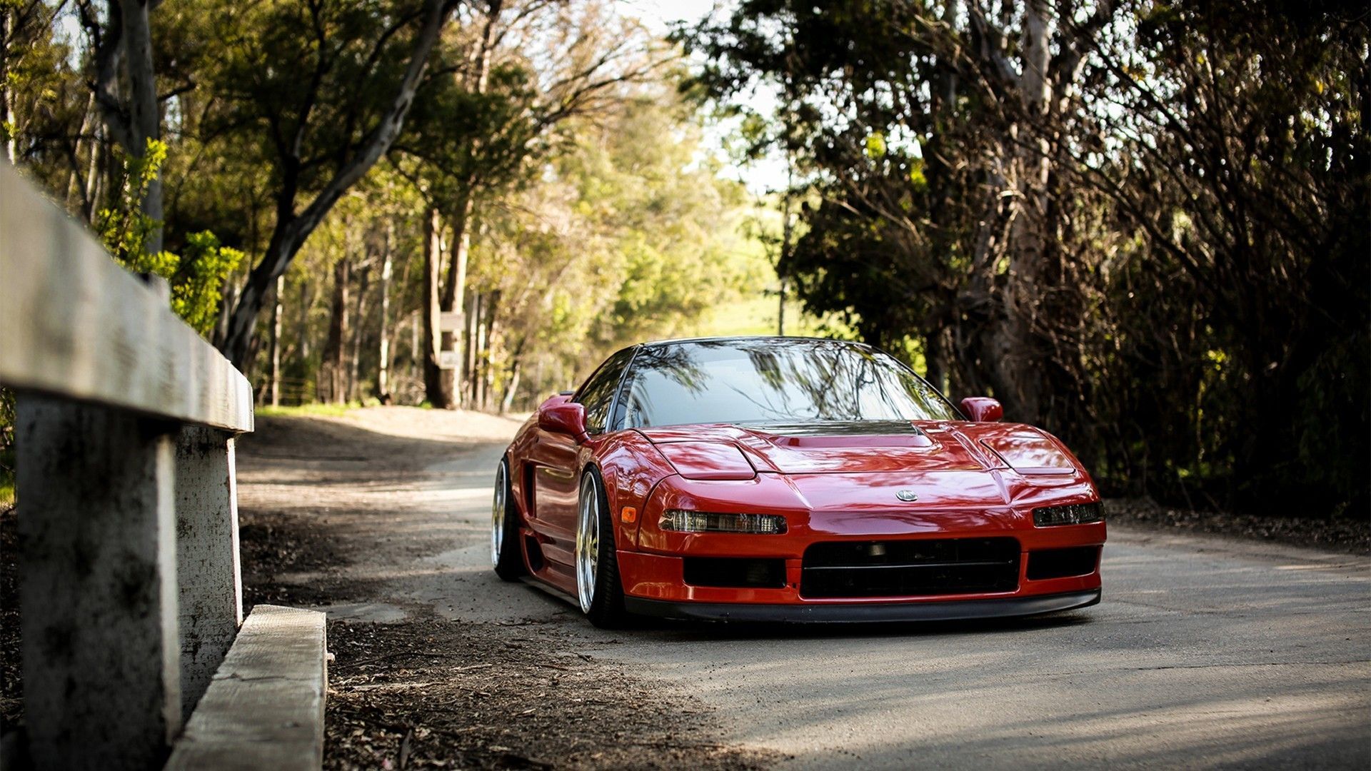 A red sports car driving down the road - JDM