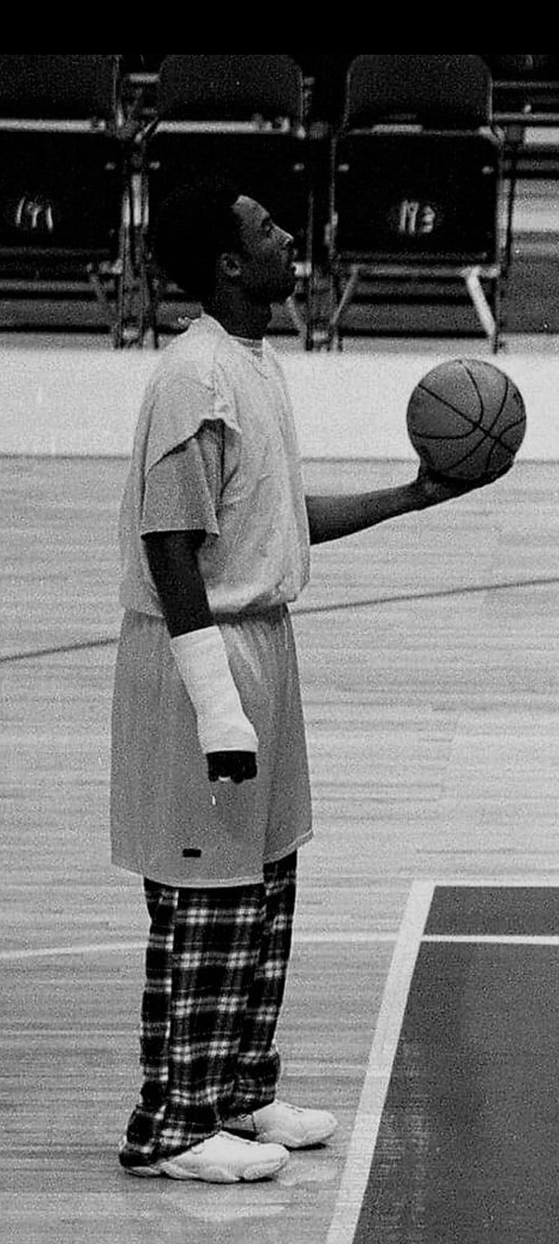 A man in pajamas is holding up basketball - NBA, Kobe Bryant
