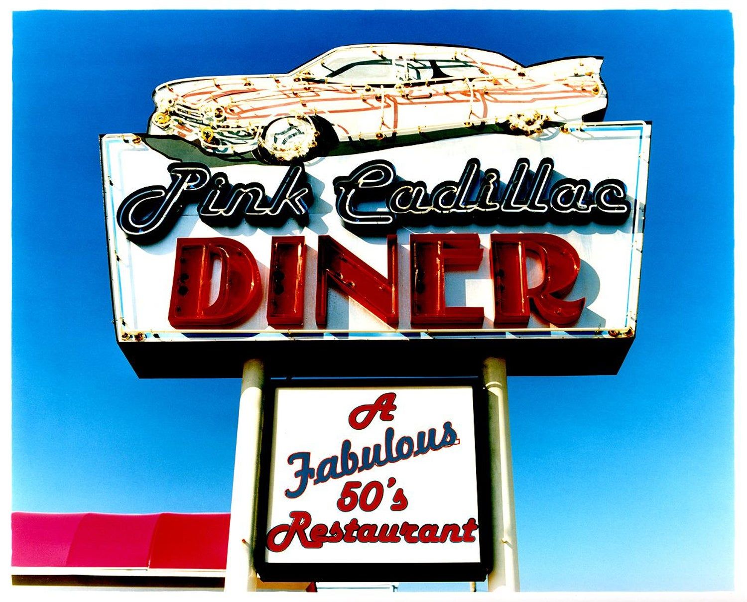 A sign for the Pink Cadillac Diner with a car on top. - 50s