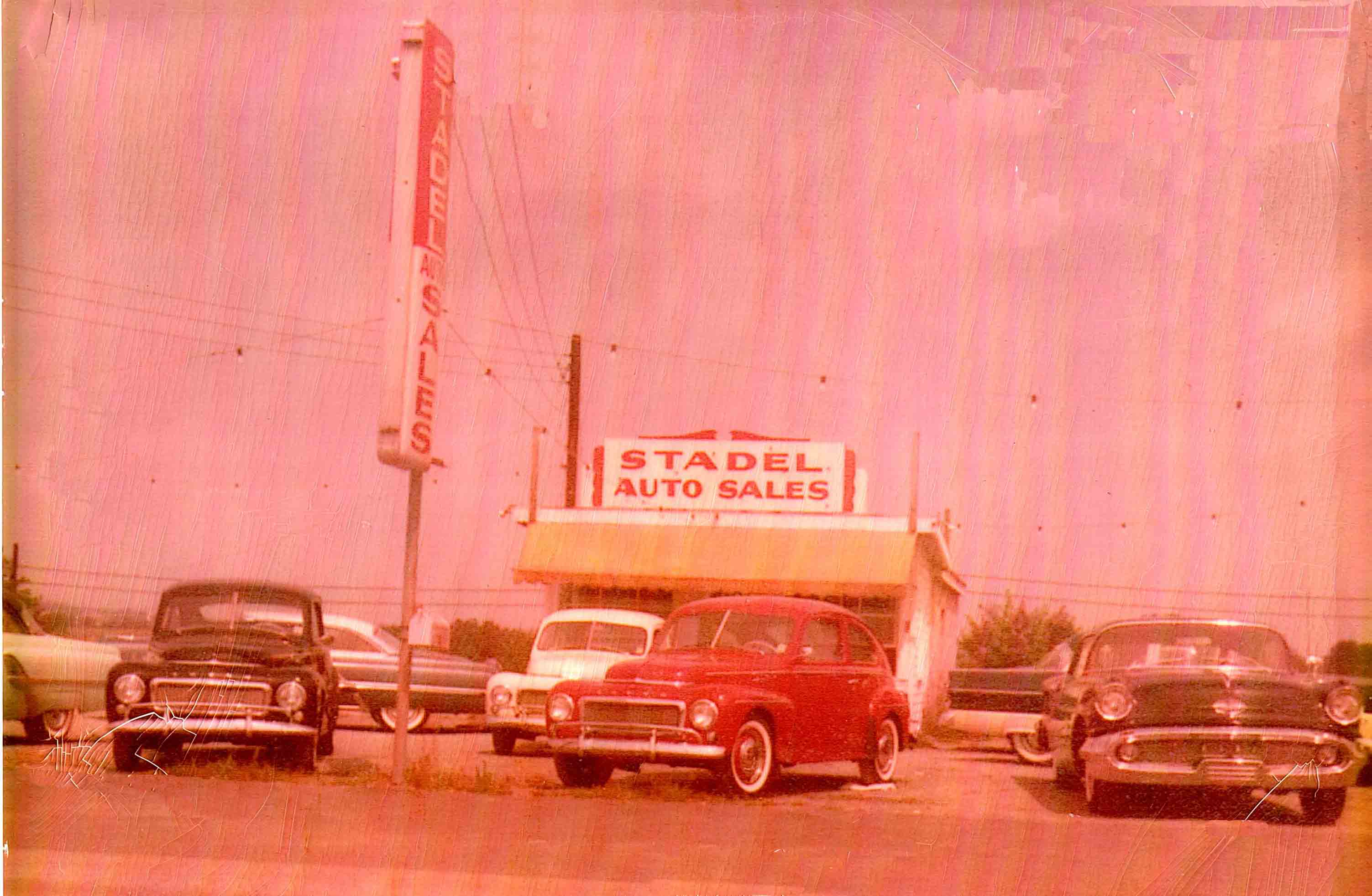 A photo of a car lot with several cars on display. - 50s