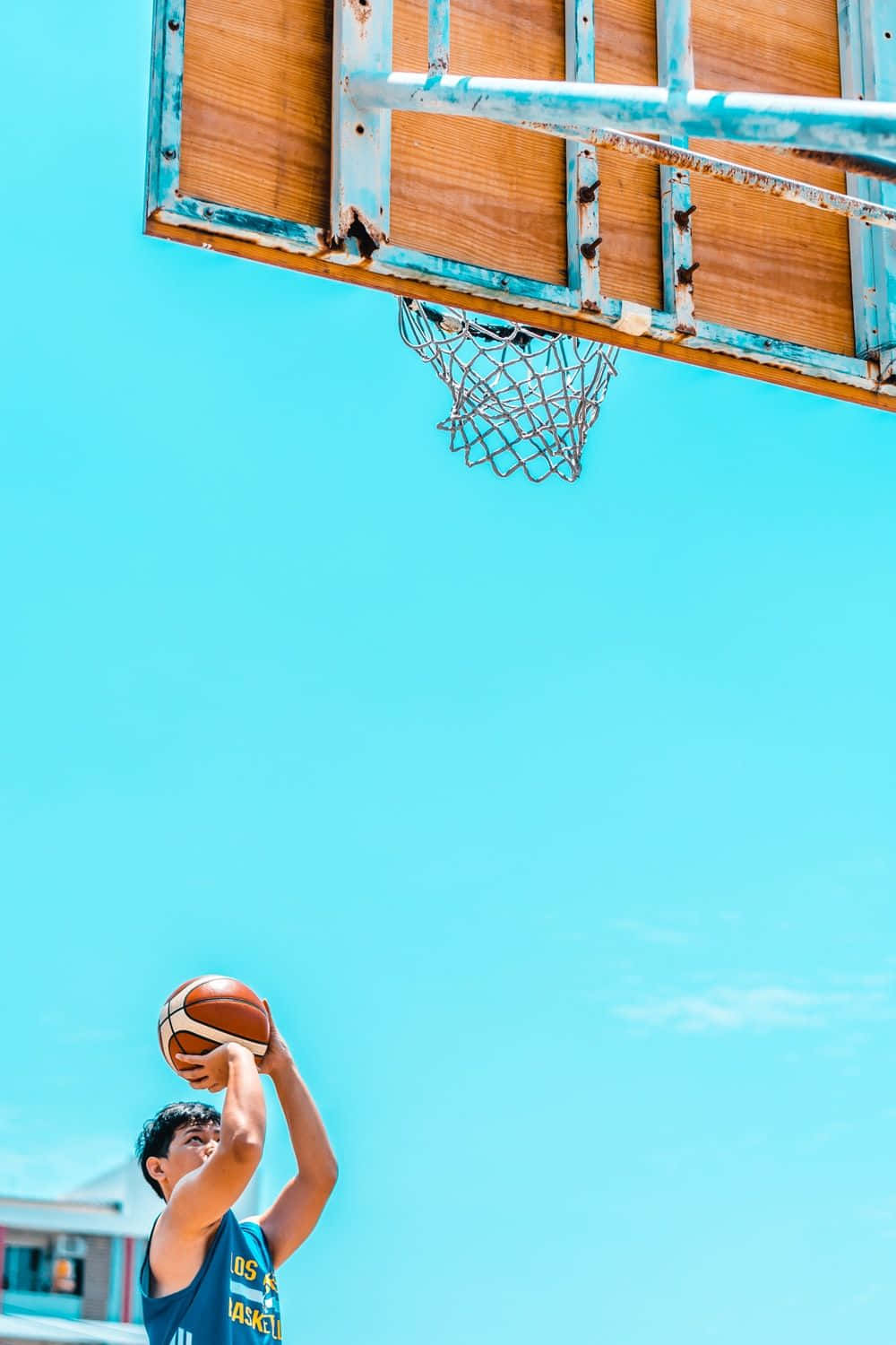 A man playing basketball in the sun - Basketball