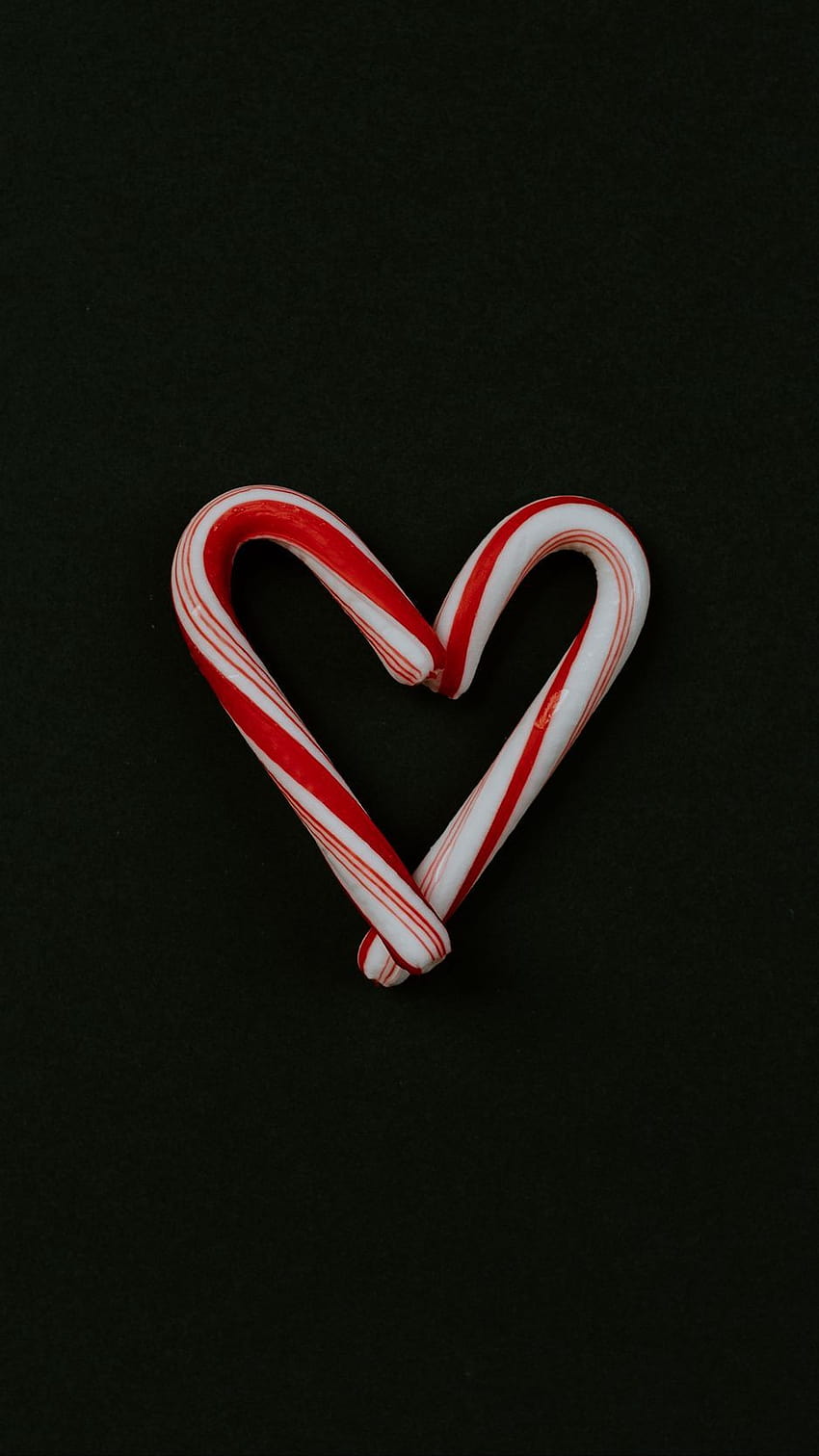 A heart shaped candy cane on black background - Candy cane