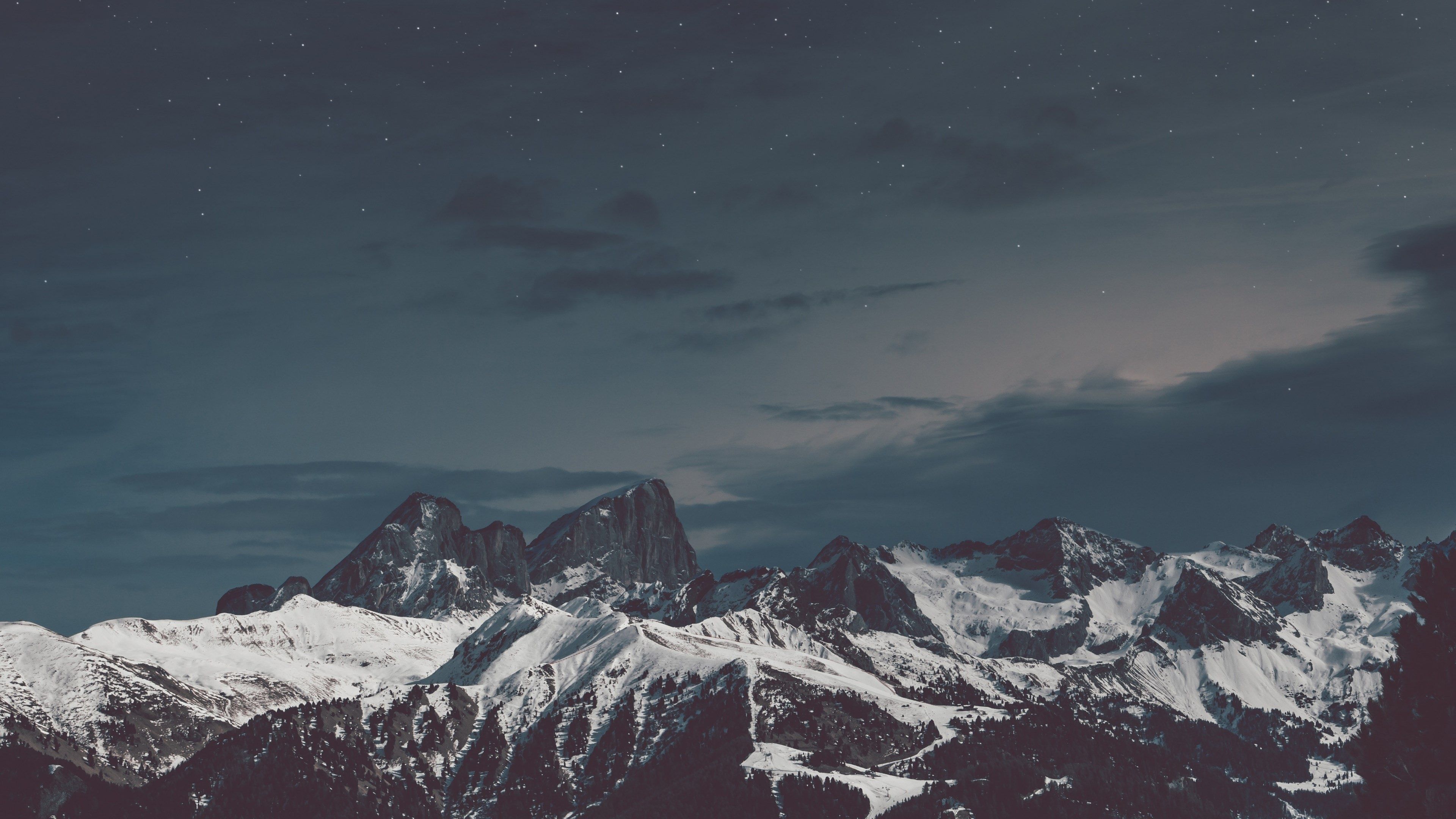A snow-covered mountain range under a starry sky - Mountain