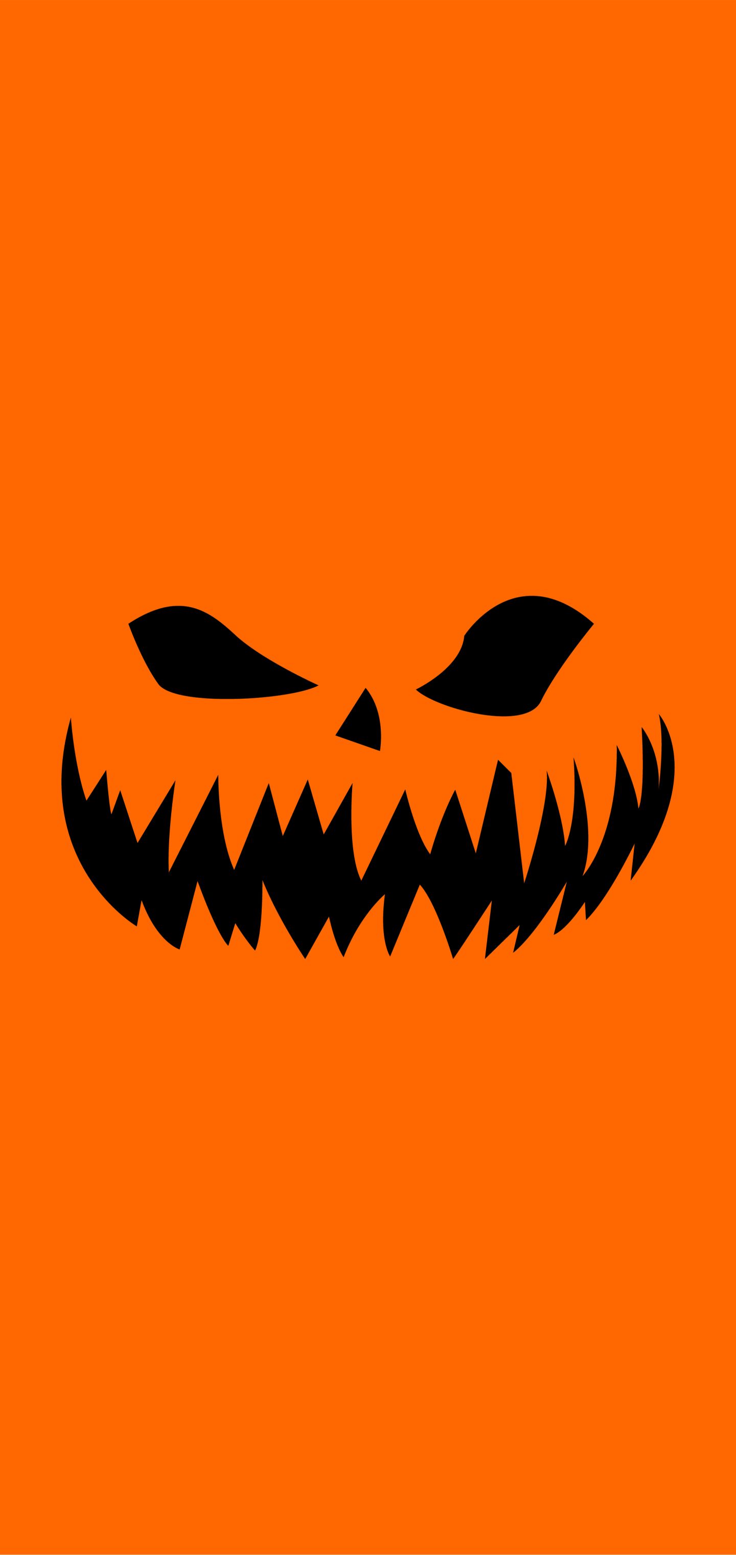Scary pumpkin face on a orange background - Halloween, spooky