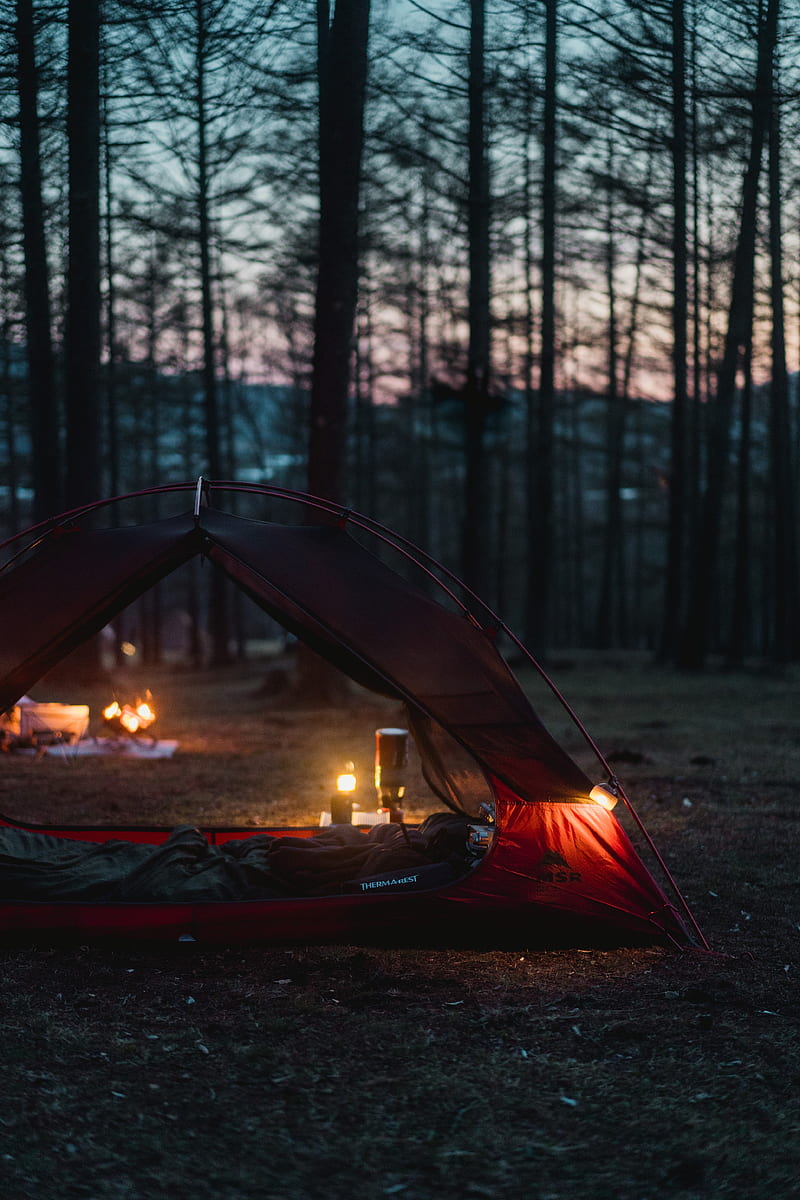 A tent with candles in it sitting on the ground - Camping