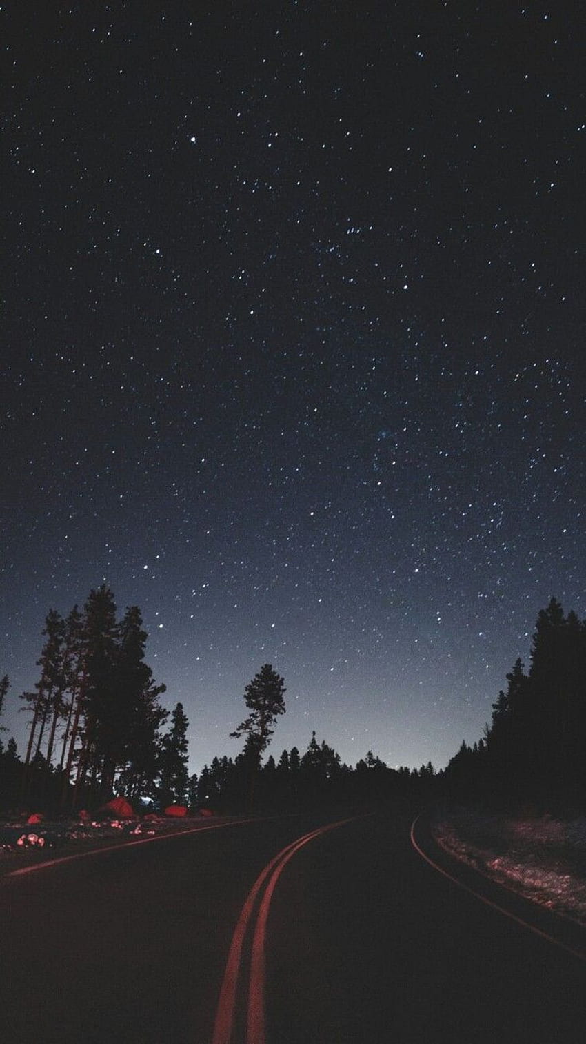 A road in the middle of the night with a starry sky above - Camping