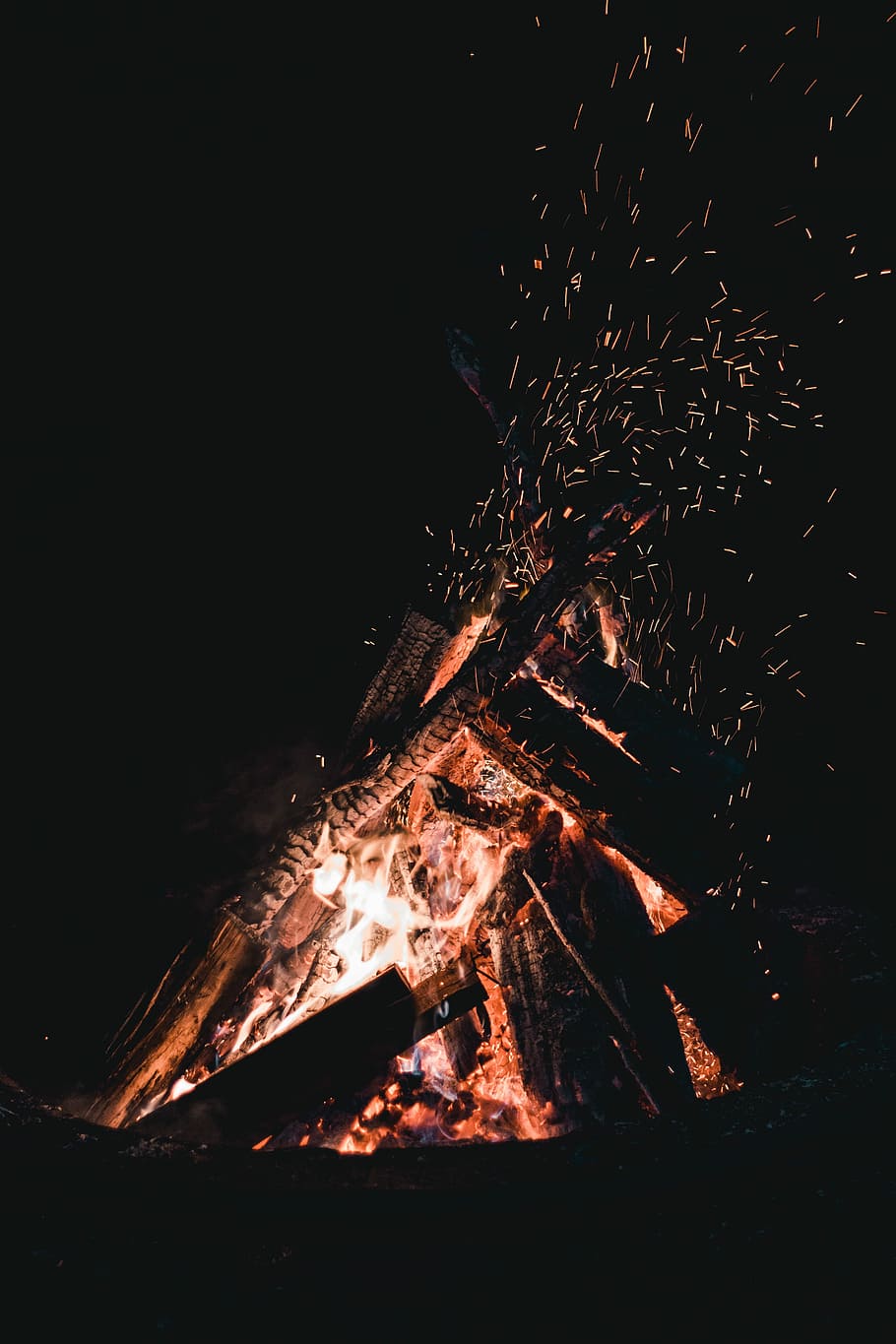 A bonfire with burning wood and sparks flying - Camping