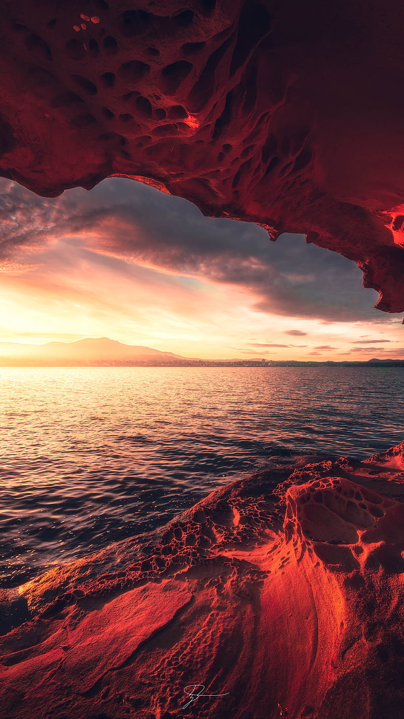 A sunset view from a red cave in the sea - Crimson