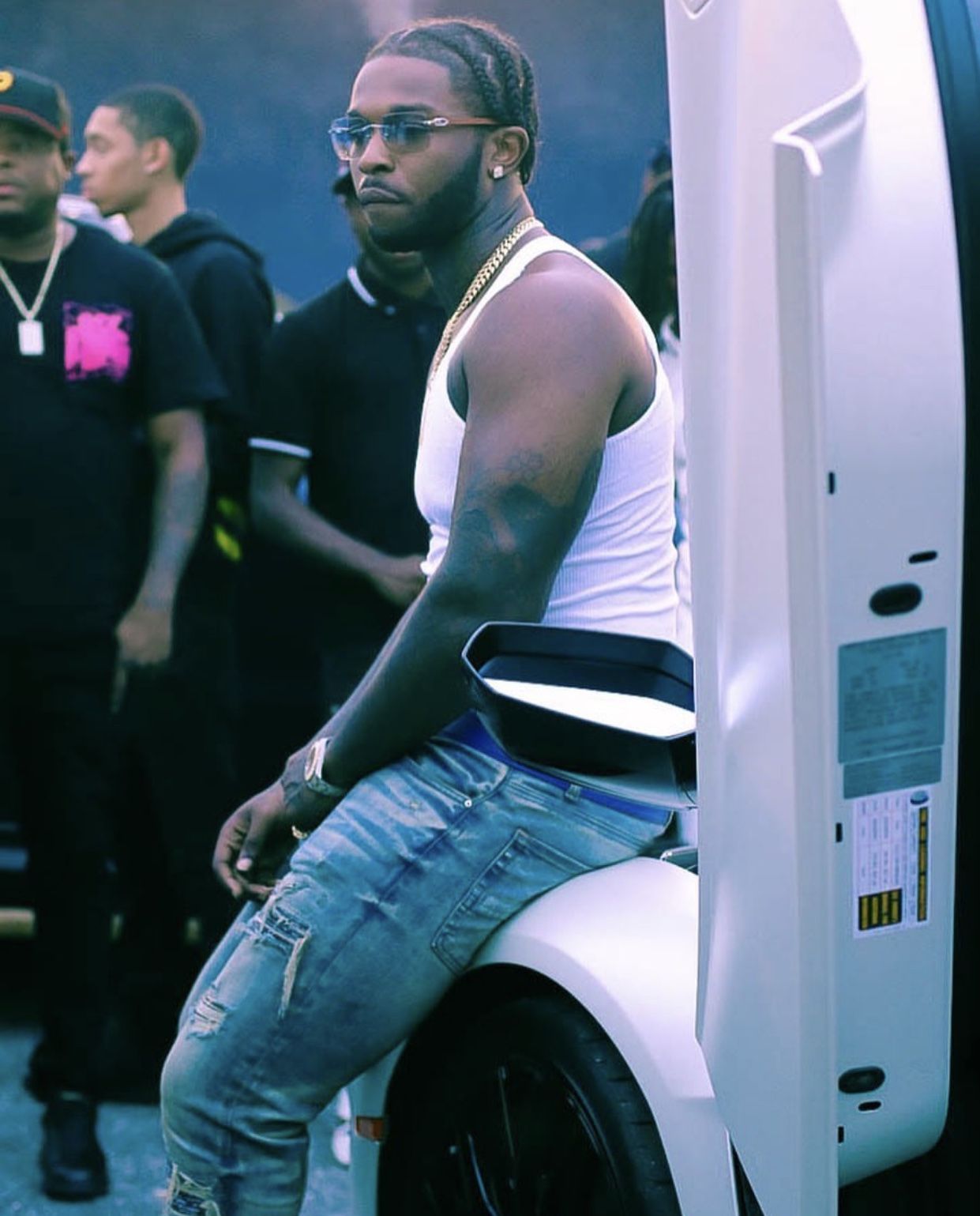 A man sitting on top of an electric car - Pop Smoke