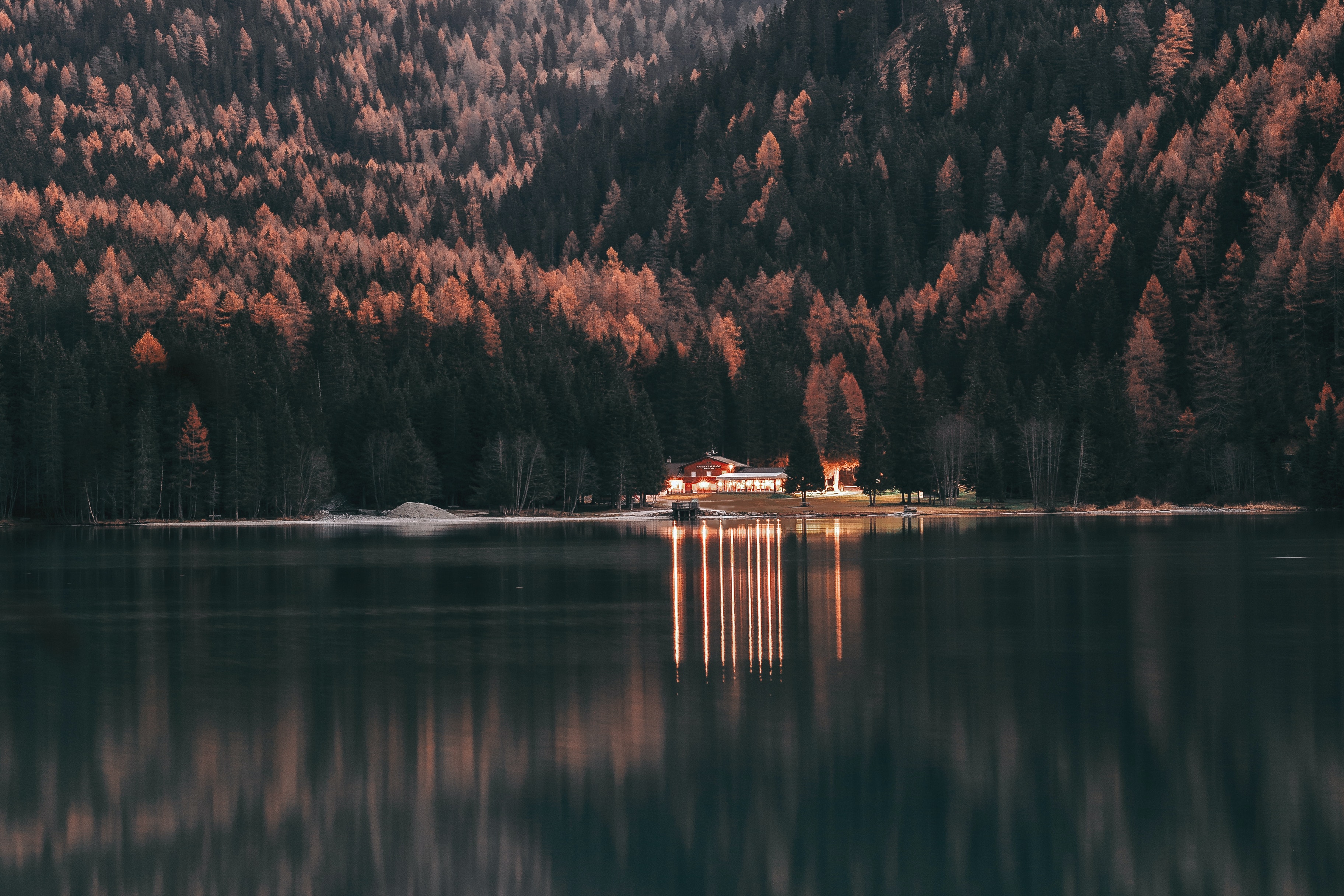 A house on a lake surrounded by trees. - Nature