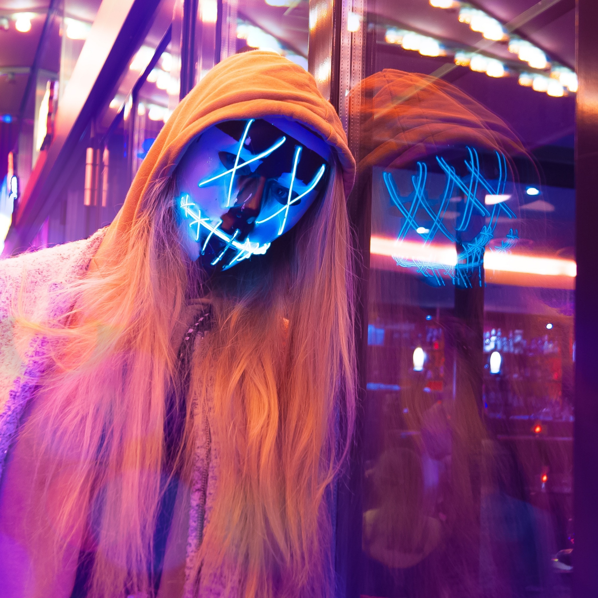 A woman with a neon mask and long blonde hair - Neon pink