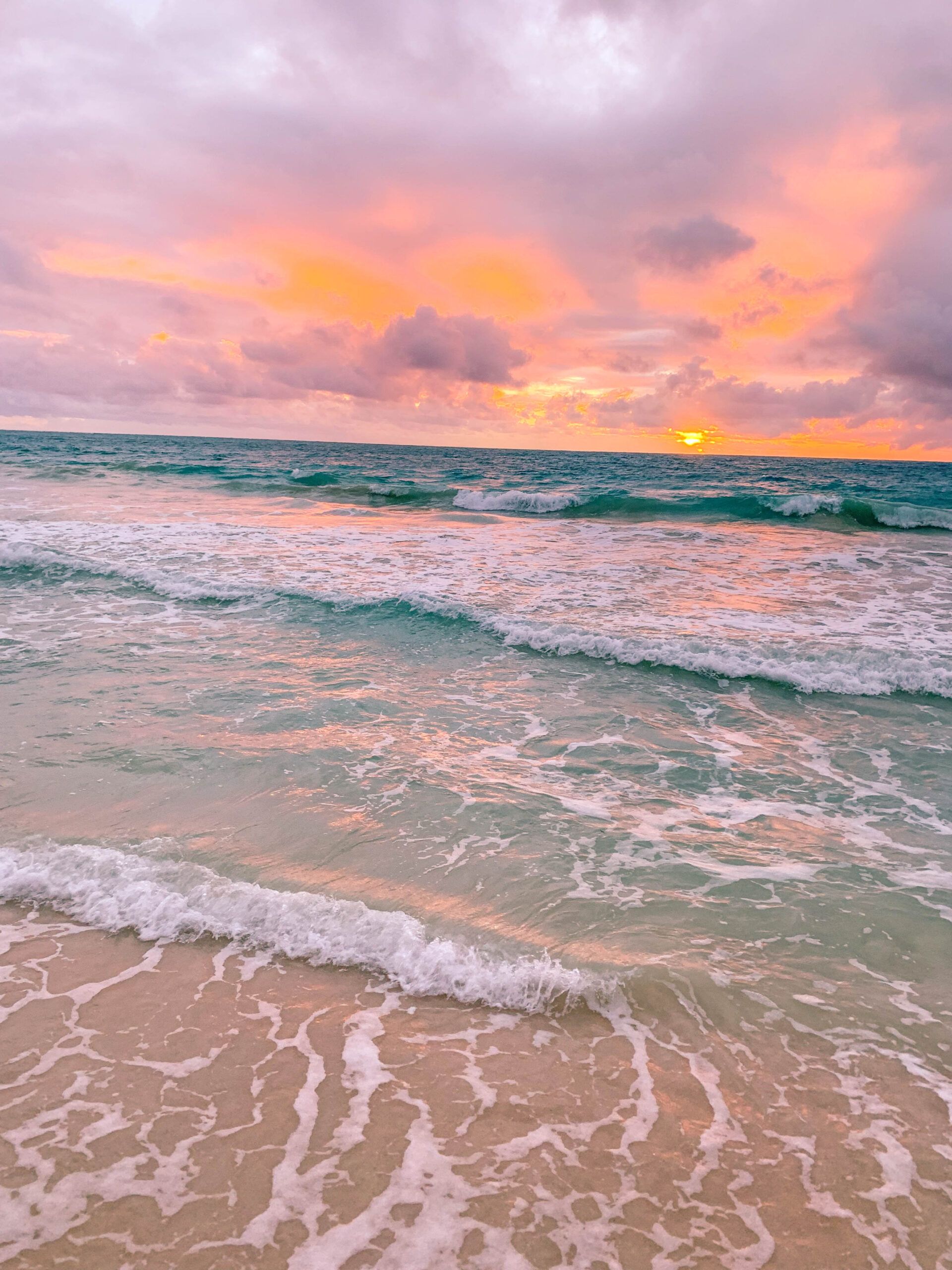 A photo of the ocean with a pink and orange sunset in the background. - Hawaii, sunrise