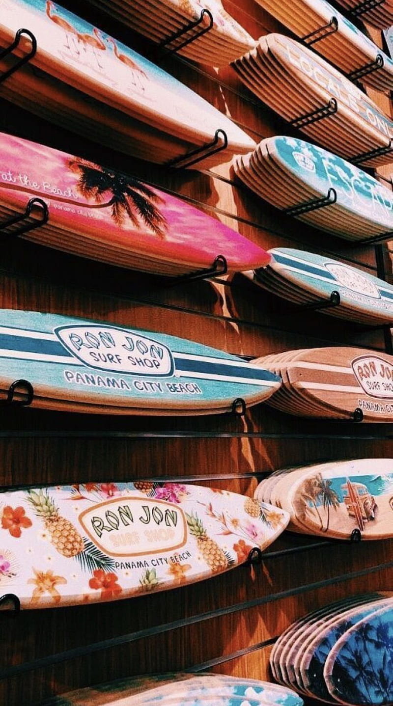 Surfboards on a wall with colorful designs. - Surf