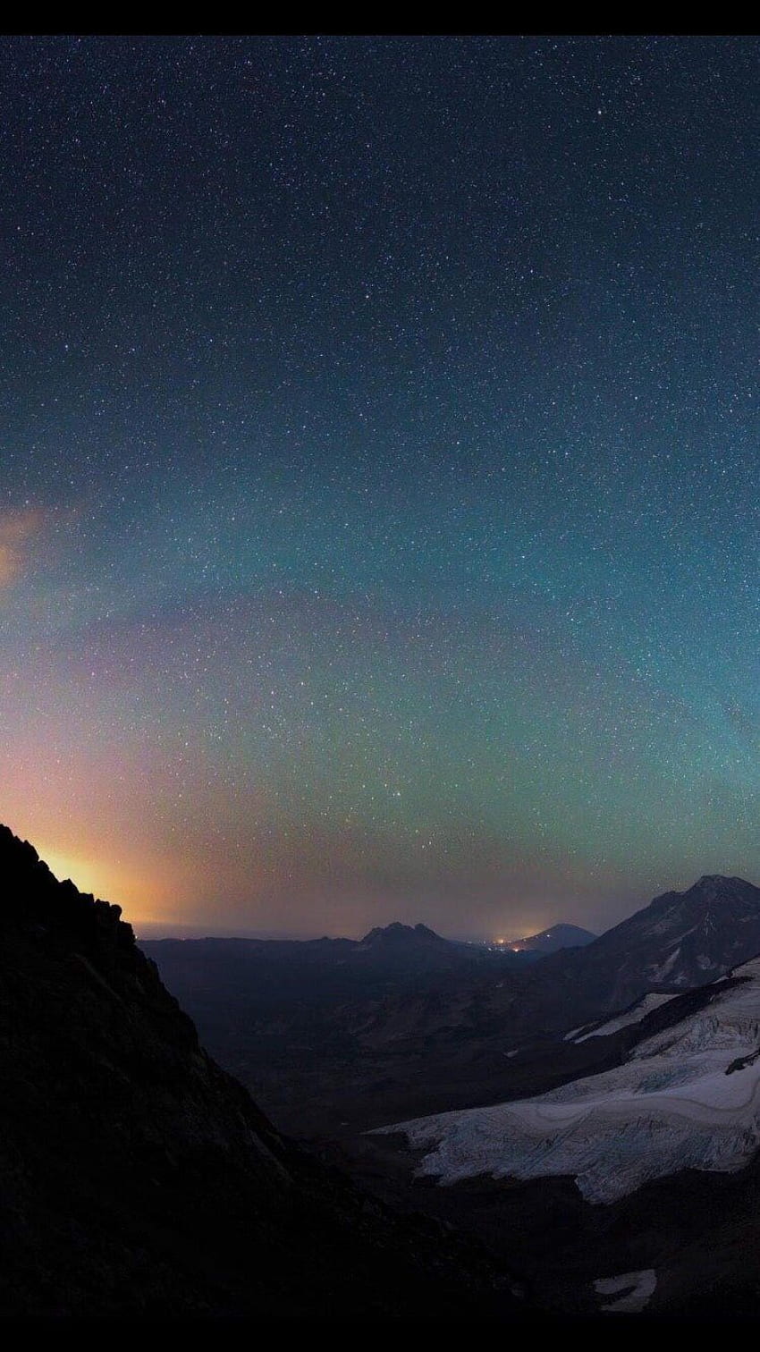 A starry sky over a snow capped mountain - Indigo