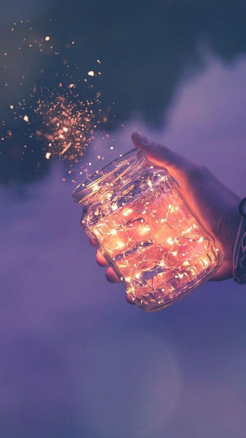 A person holding a jar with lights in it - Magic