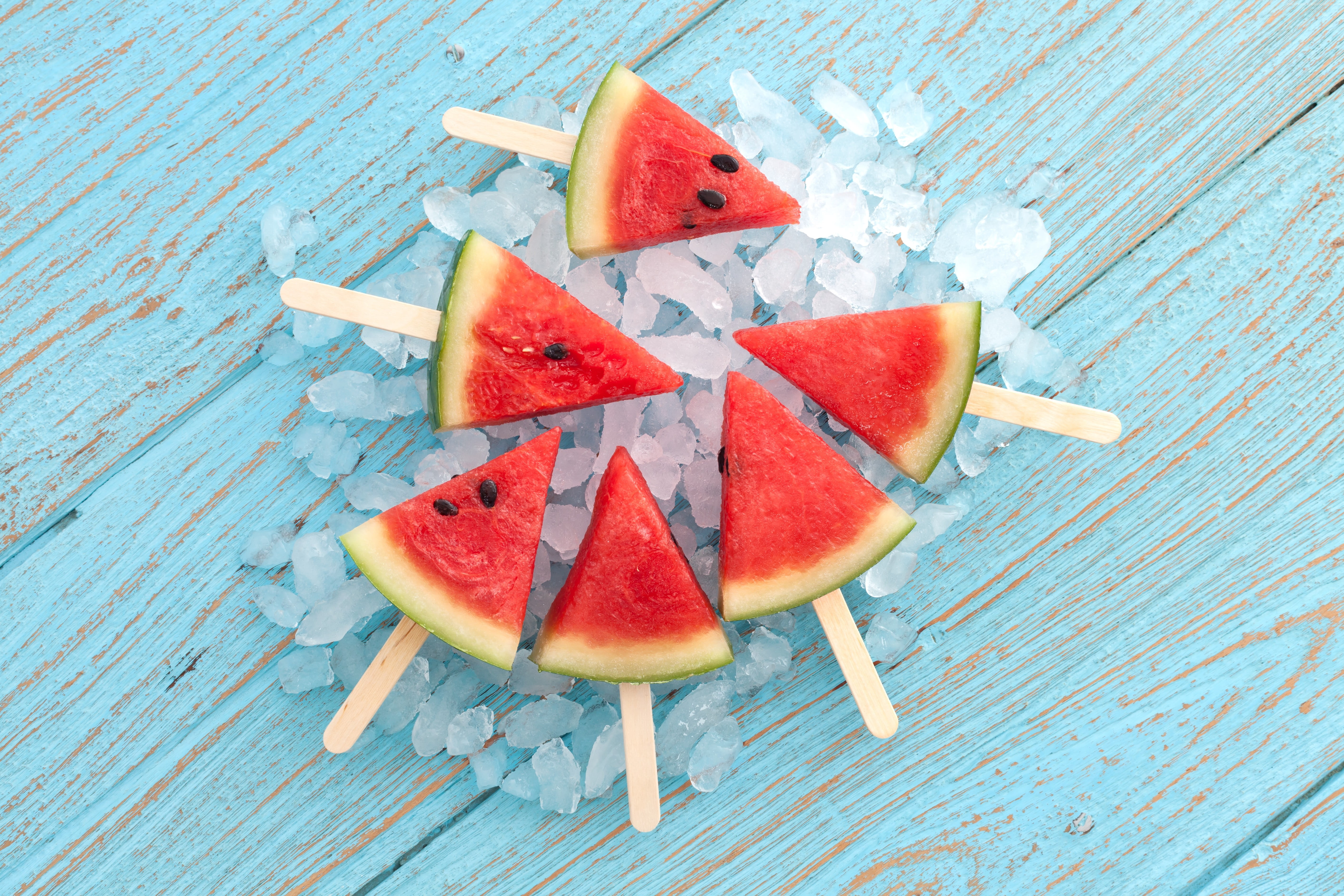 A watermelon is cut into small pieces and placed on sticks - Watermelon