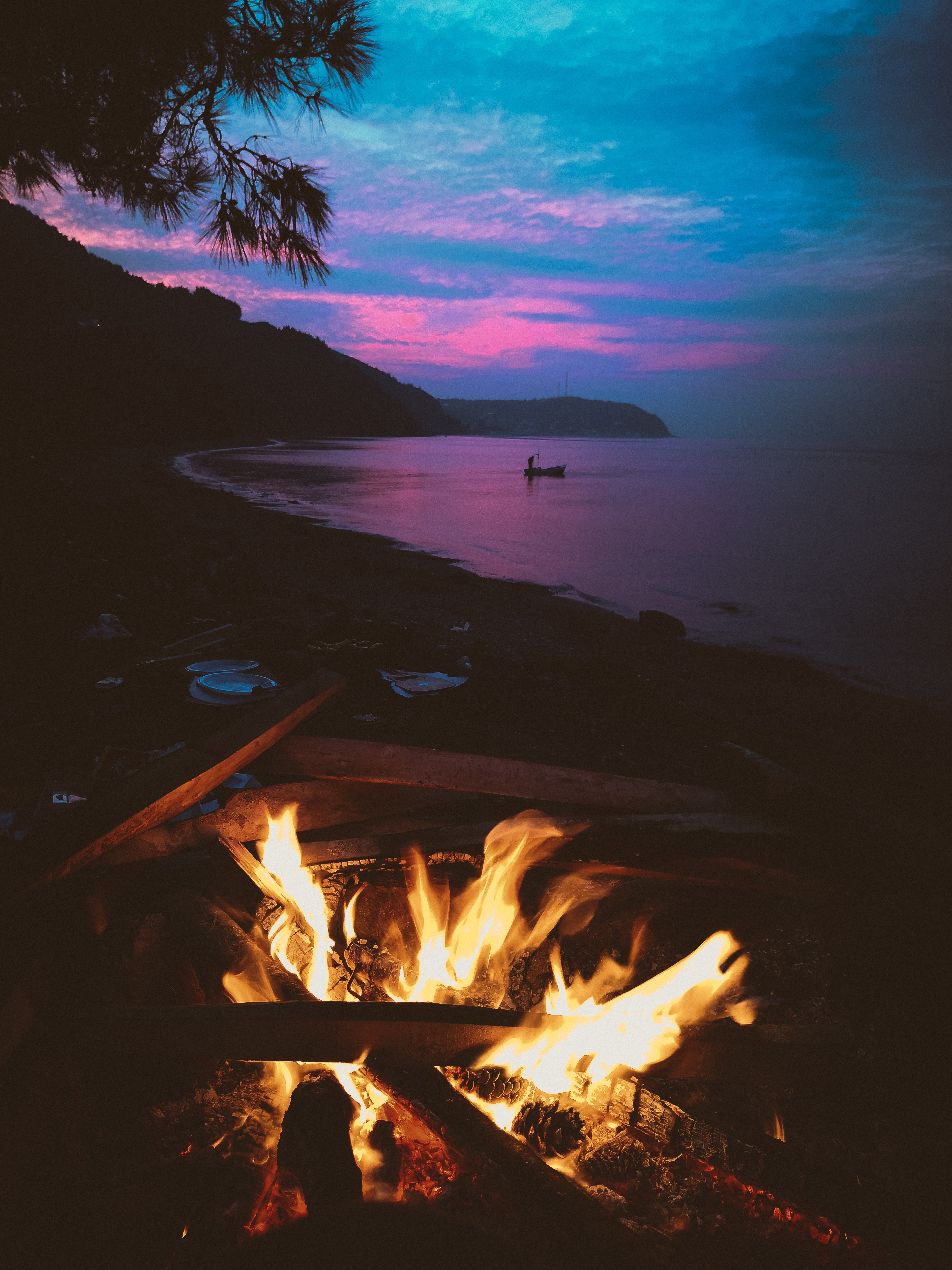 A fire is burning on the beach - Camping