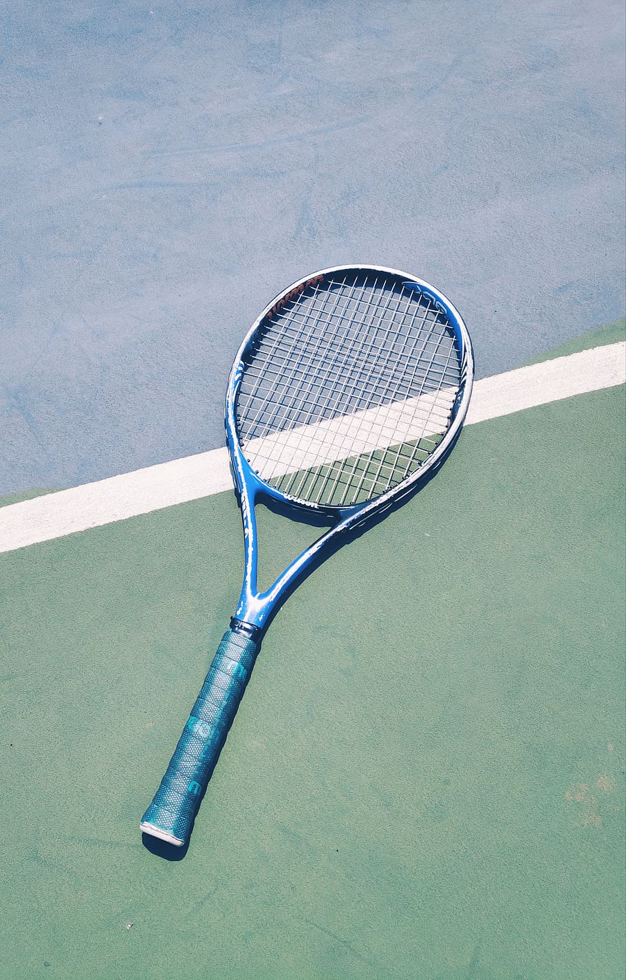 A tennis racket is laying on the ground - Tennis