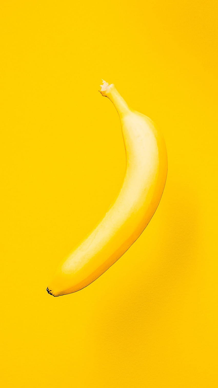 A single banana on a yellow background - Banana
